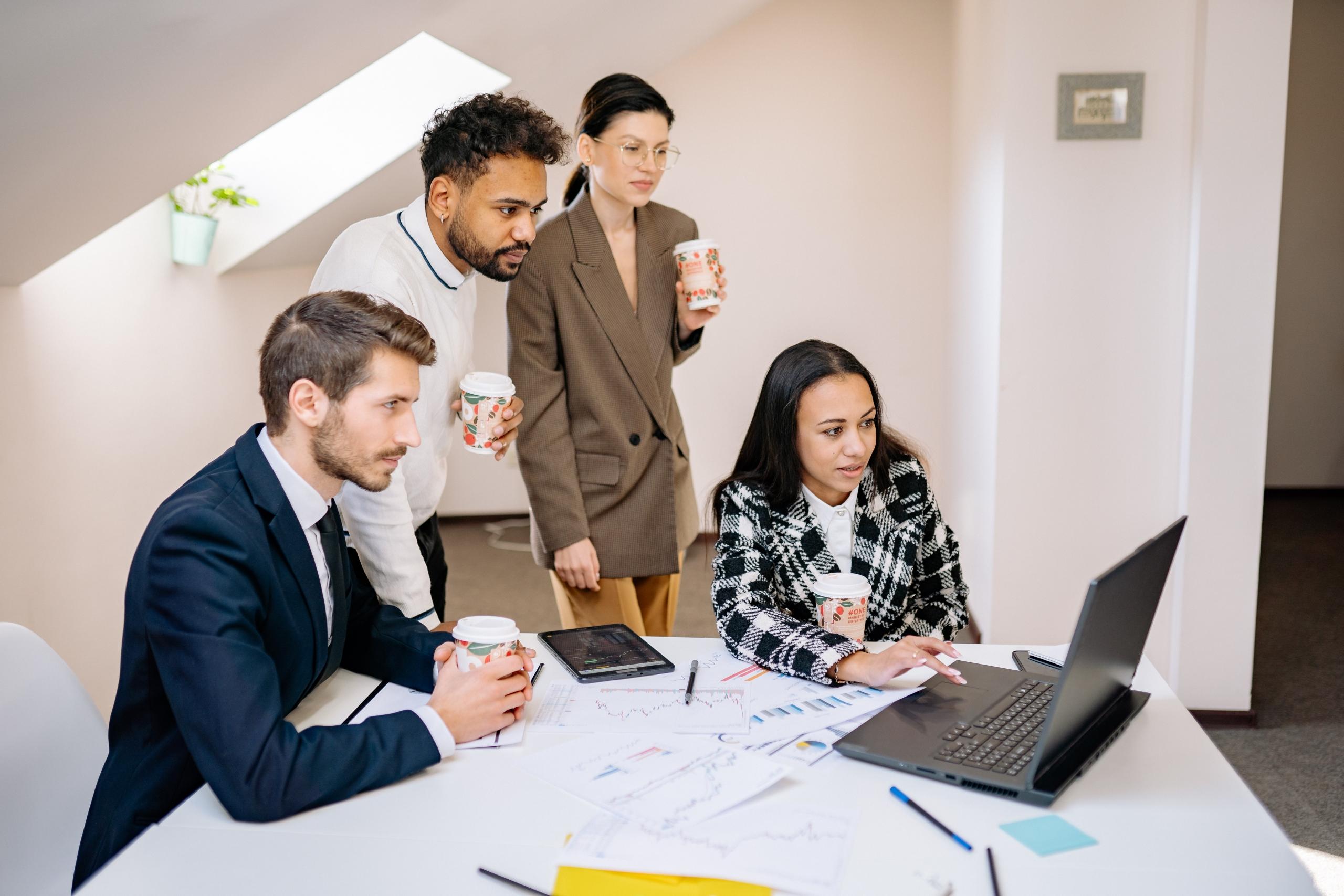 men and women meeting in boardroom reviewing documents