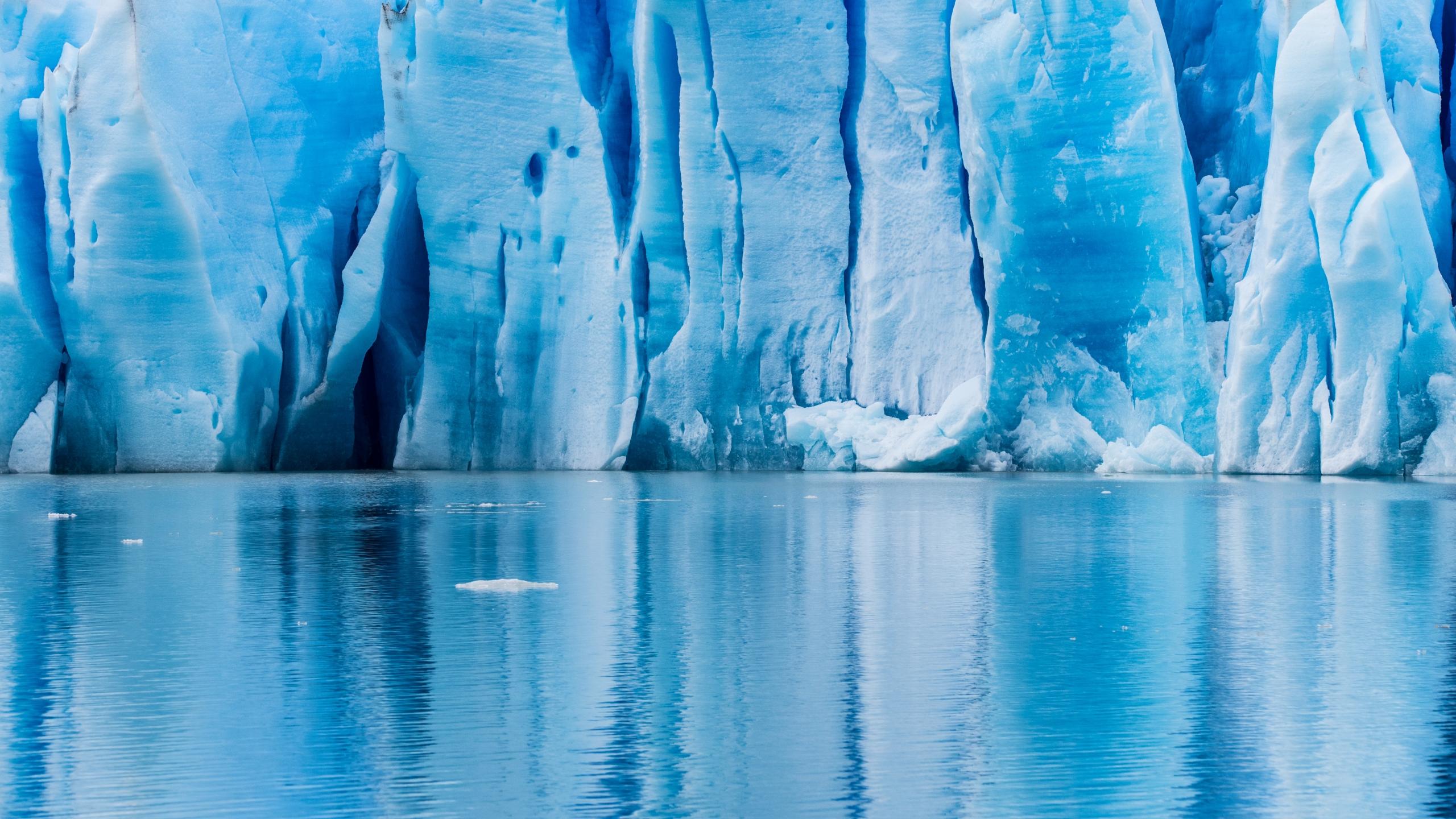cliffs of ice surrounding a blue lake