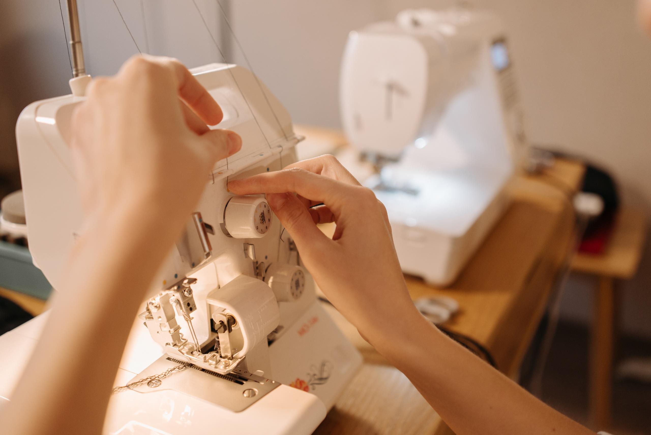 woman adding thread to sewing machine bobbins