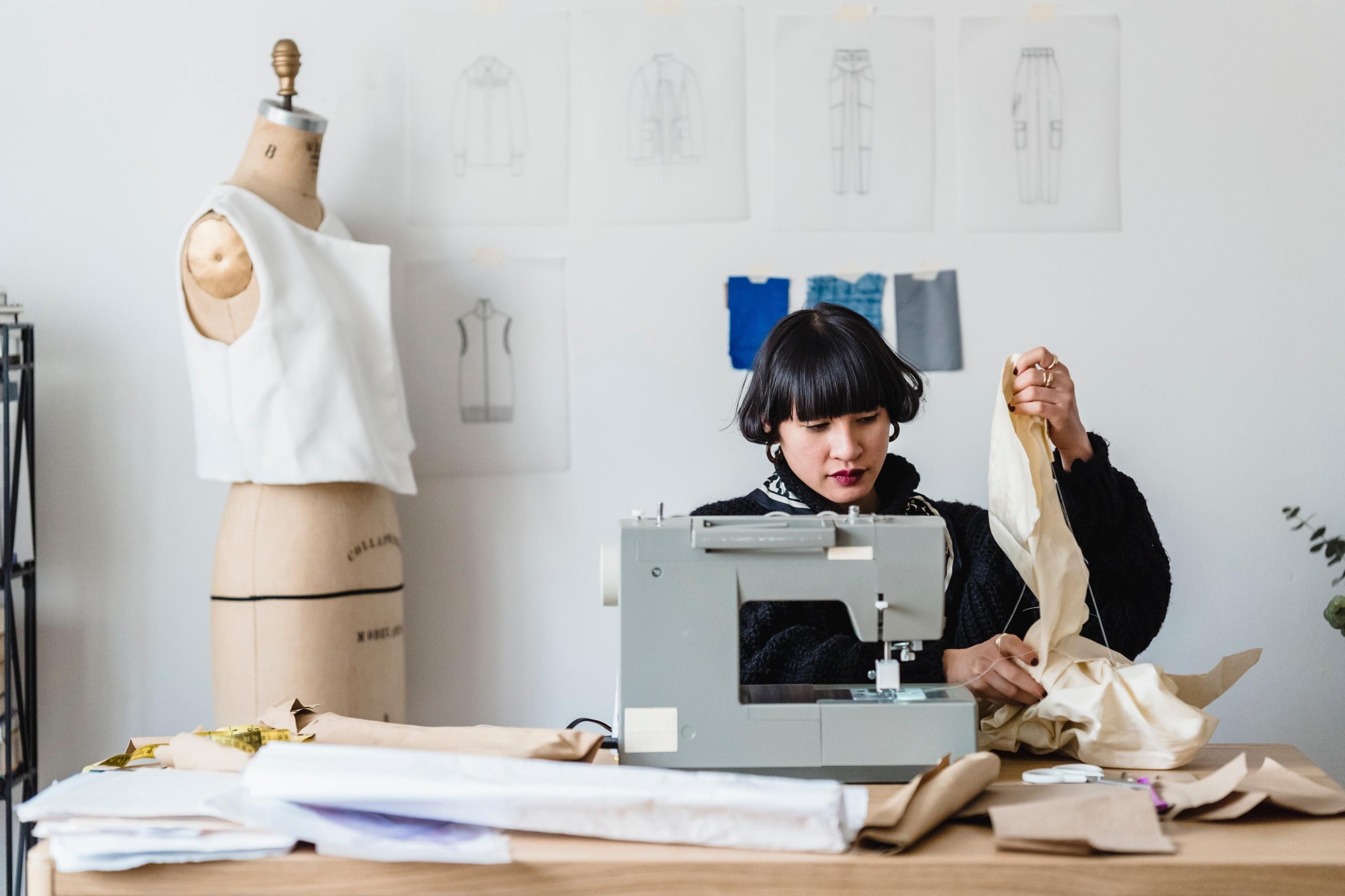 woman making clothing using sewing machine