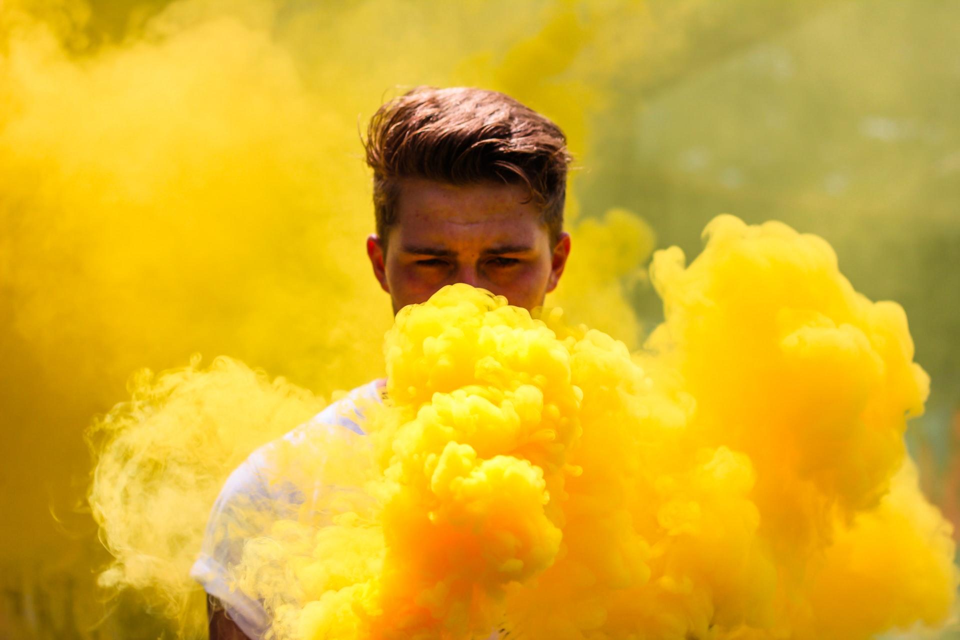 Man throwing yellow powder