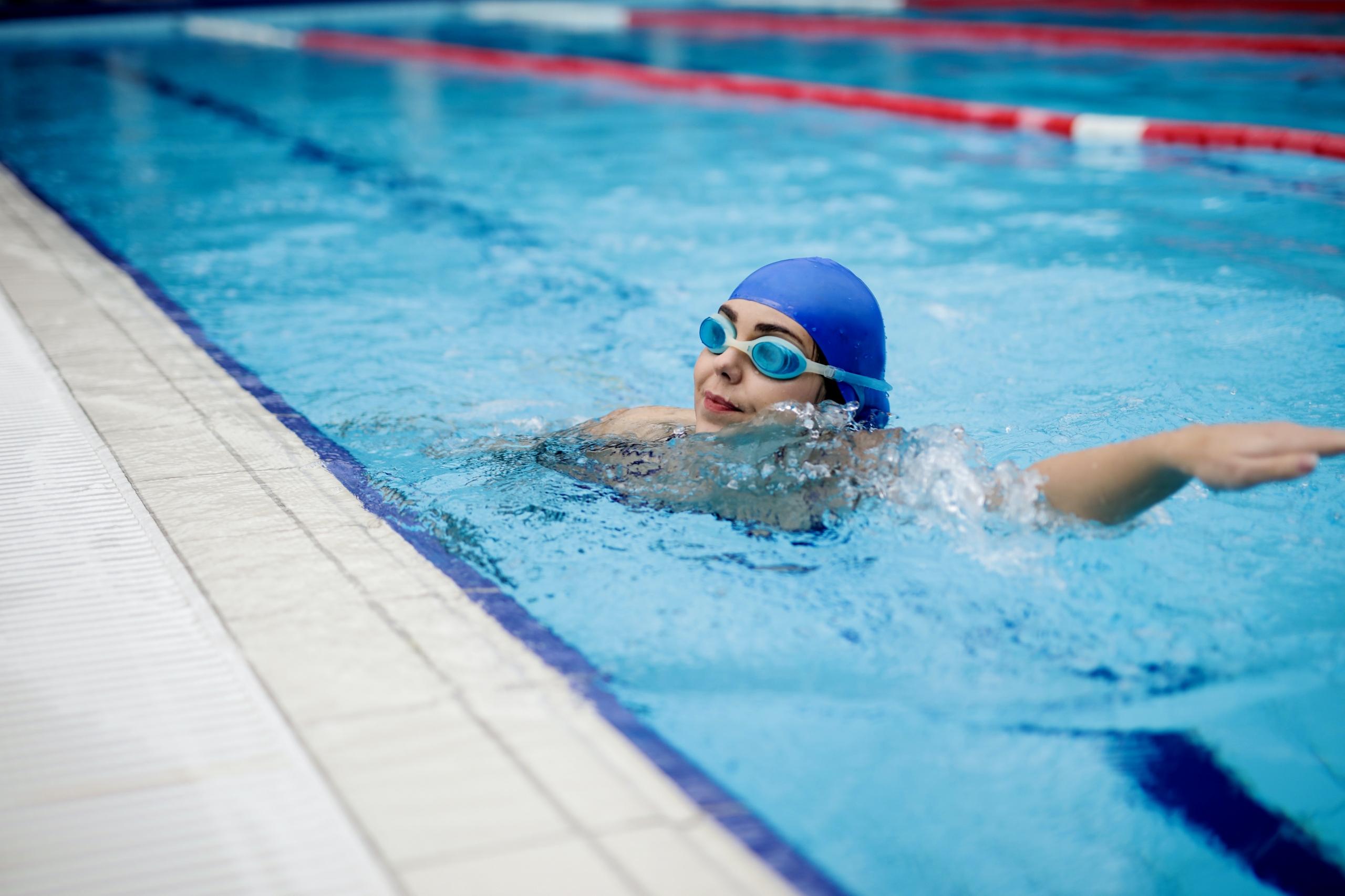 woman wearing swimming cap and googles in pool