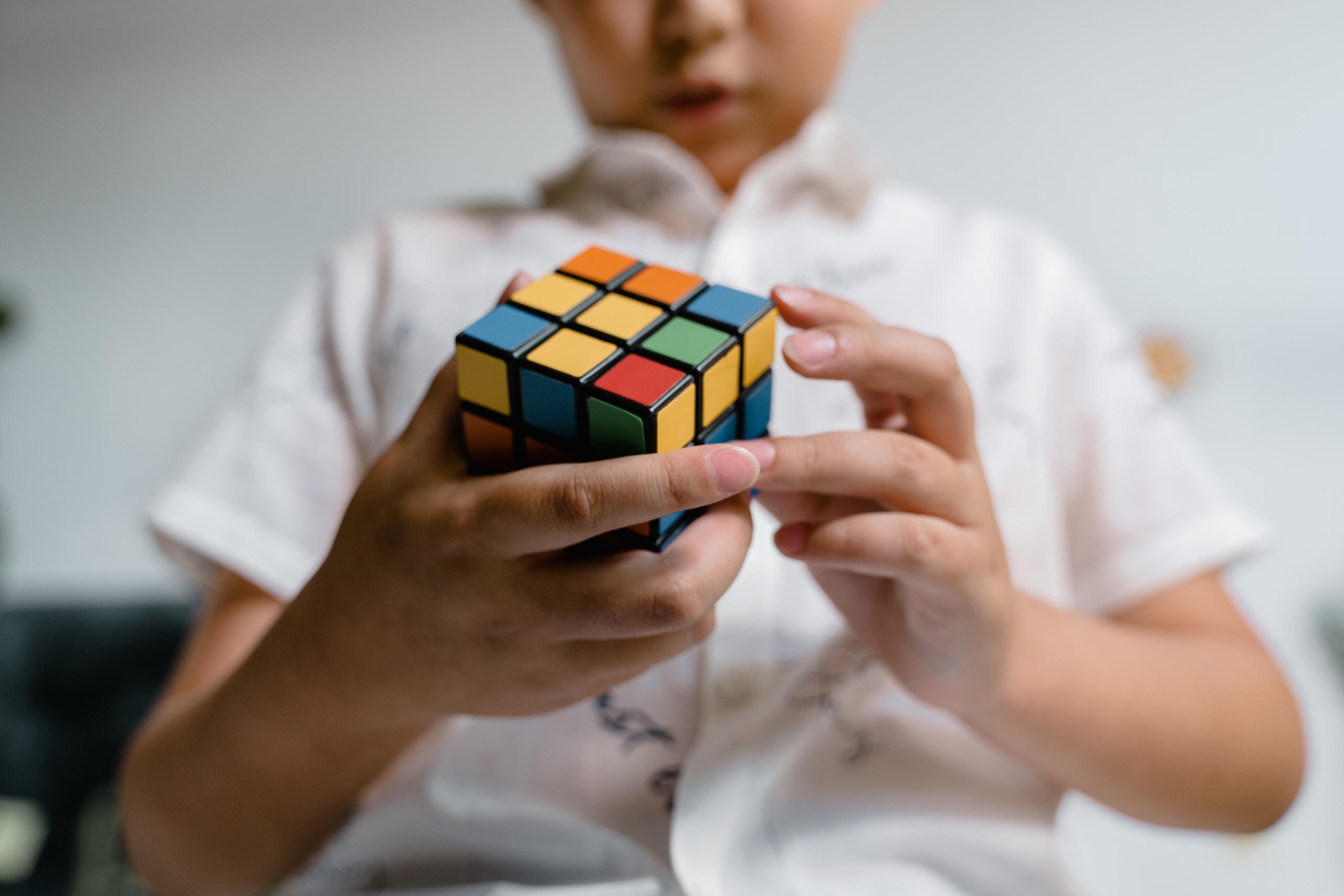 child trying to solve Rubik's cube
