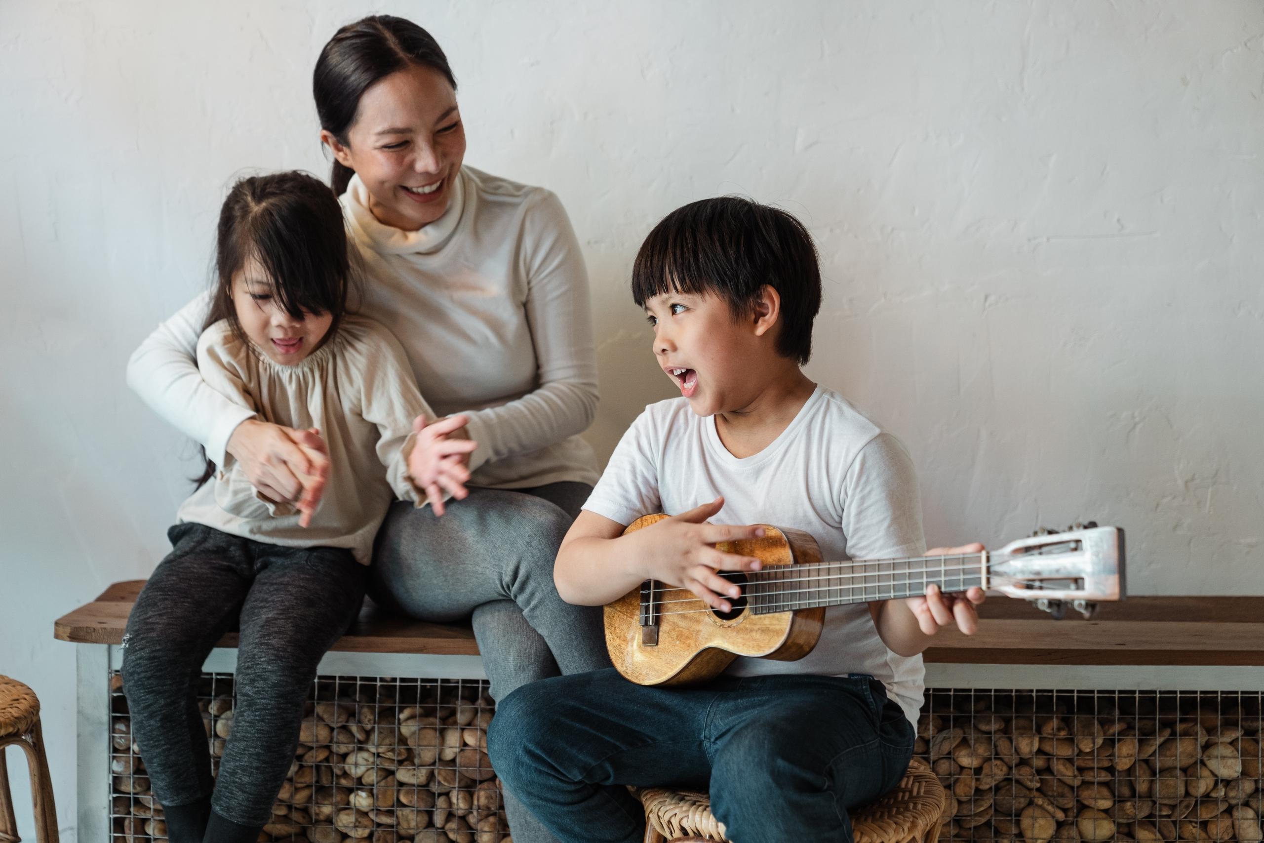 child entertaining mother and sister as he sings
