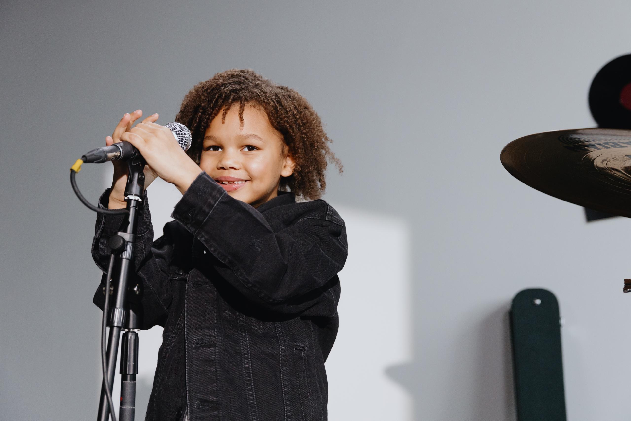 child standing behind mic stand