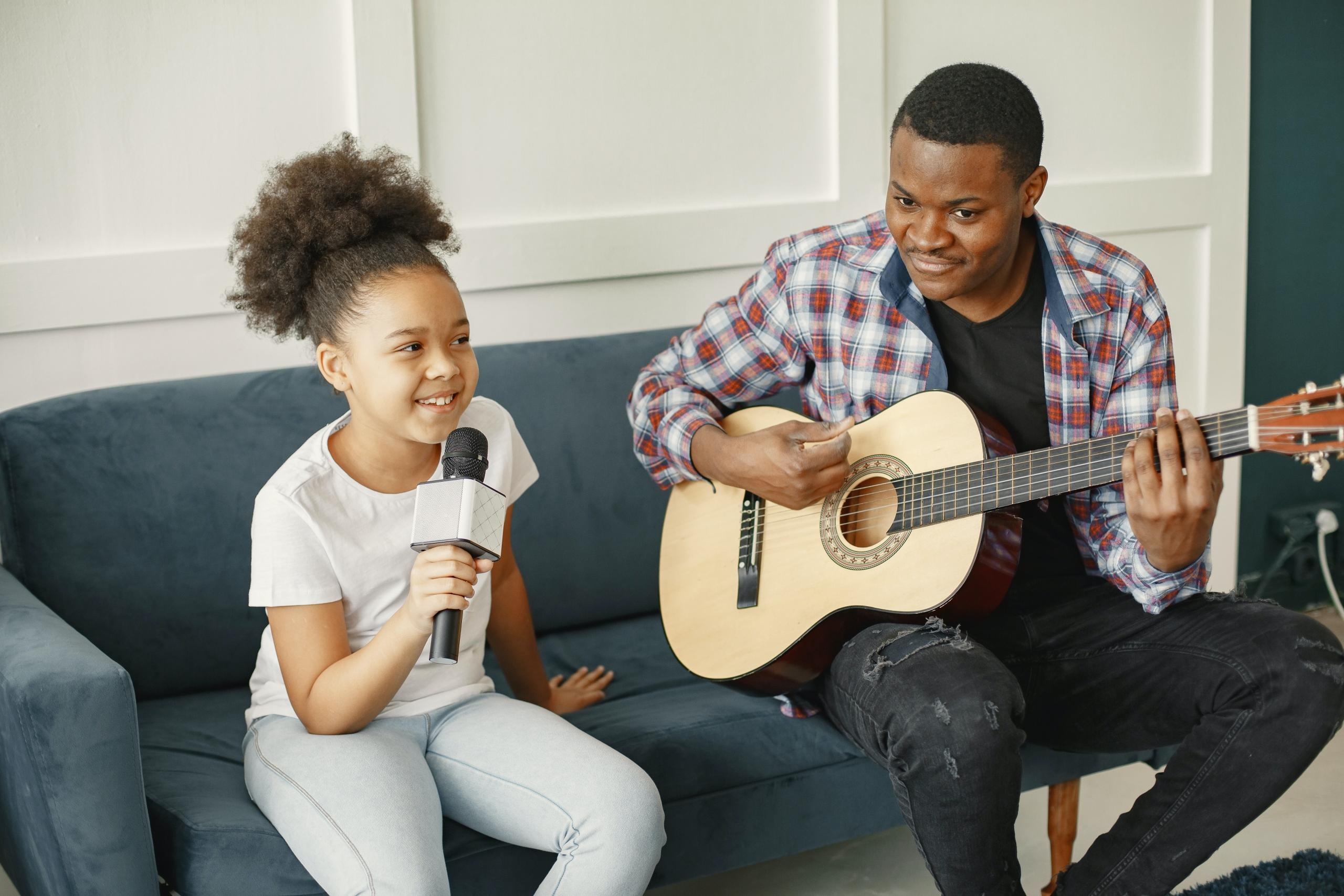 child holding mic and singing with singing teacher