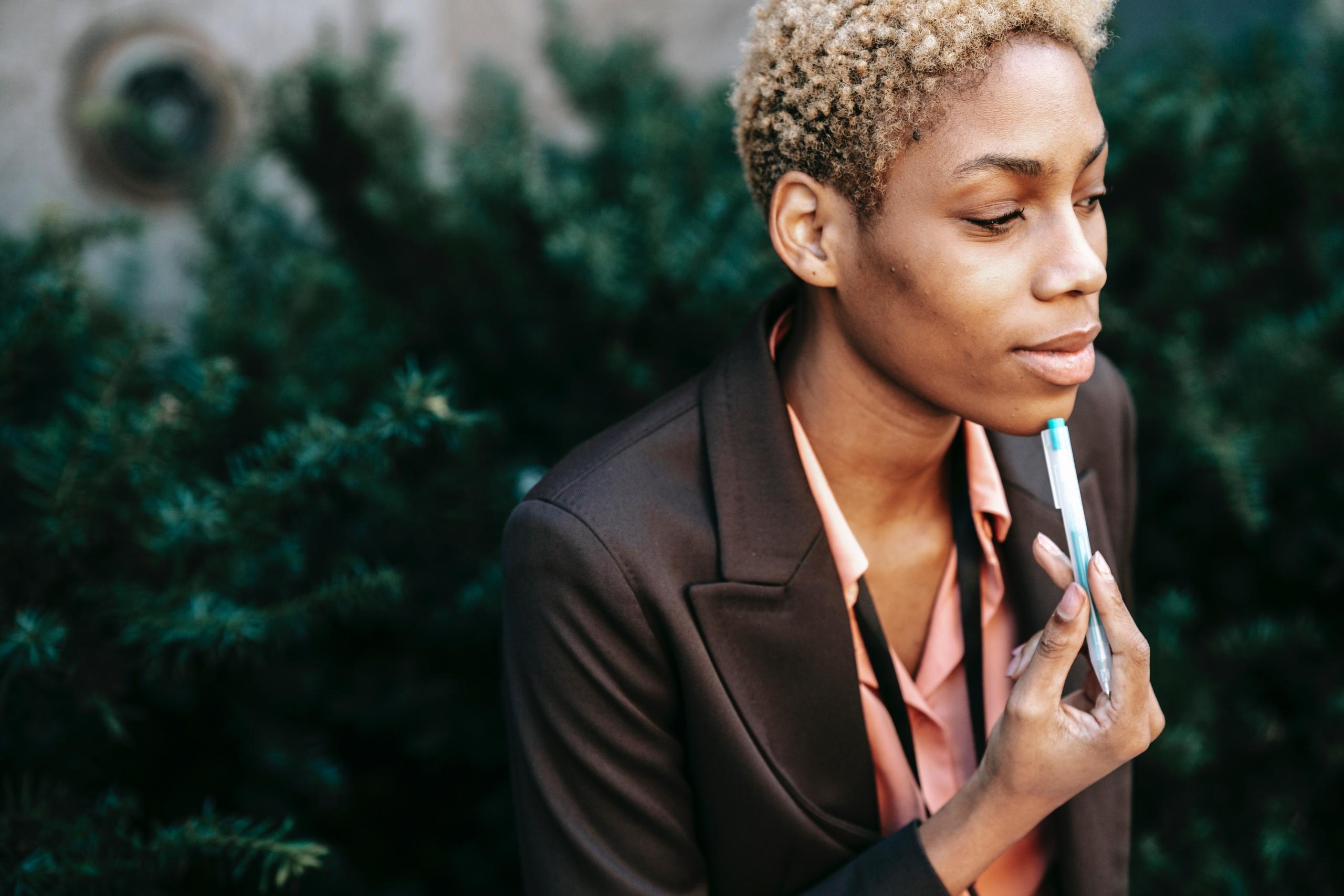 person thinking with pen pressed against face