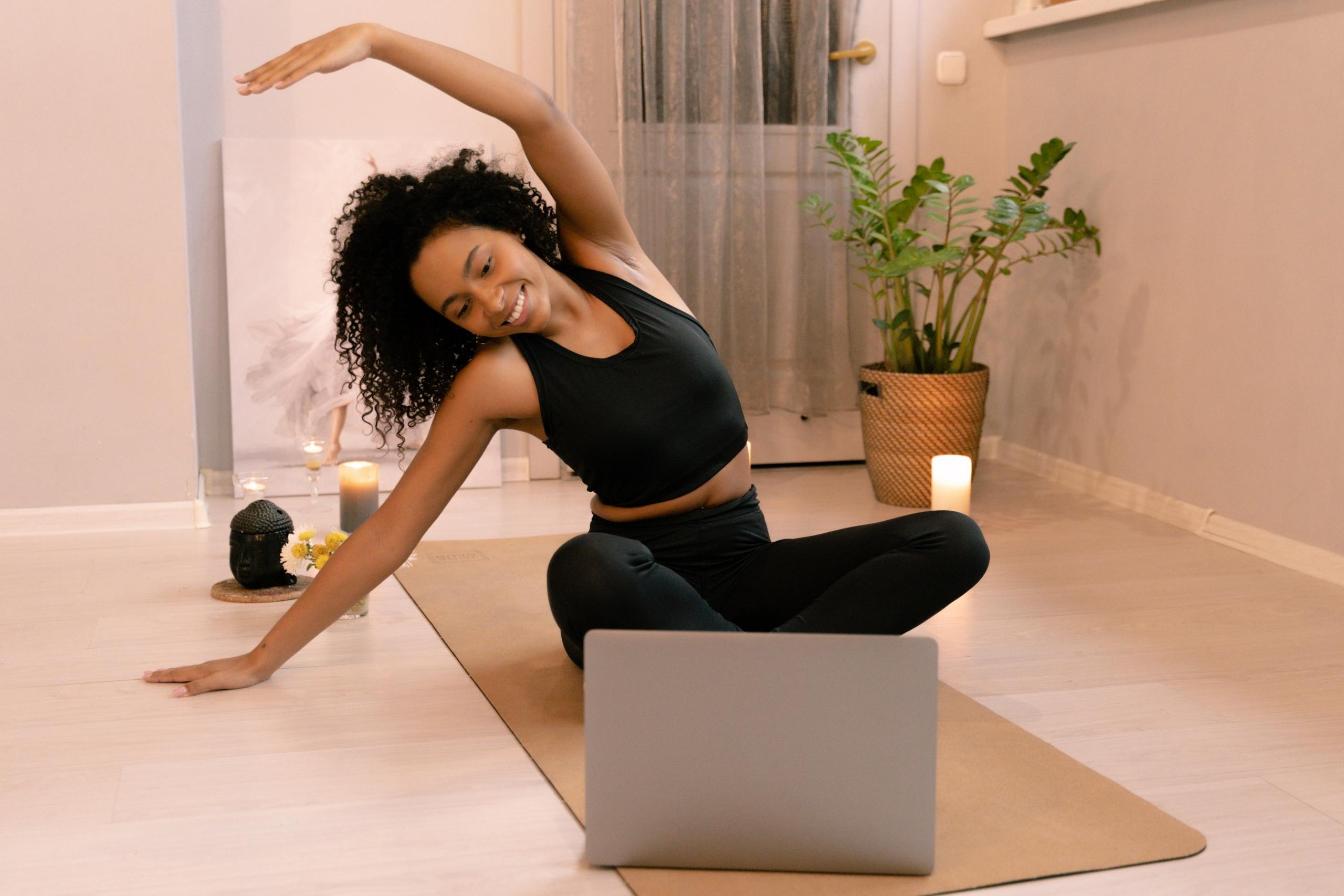 student doing online yoga class using laptop