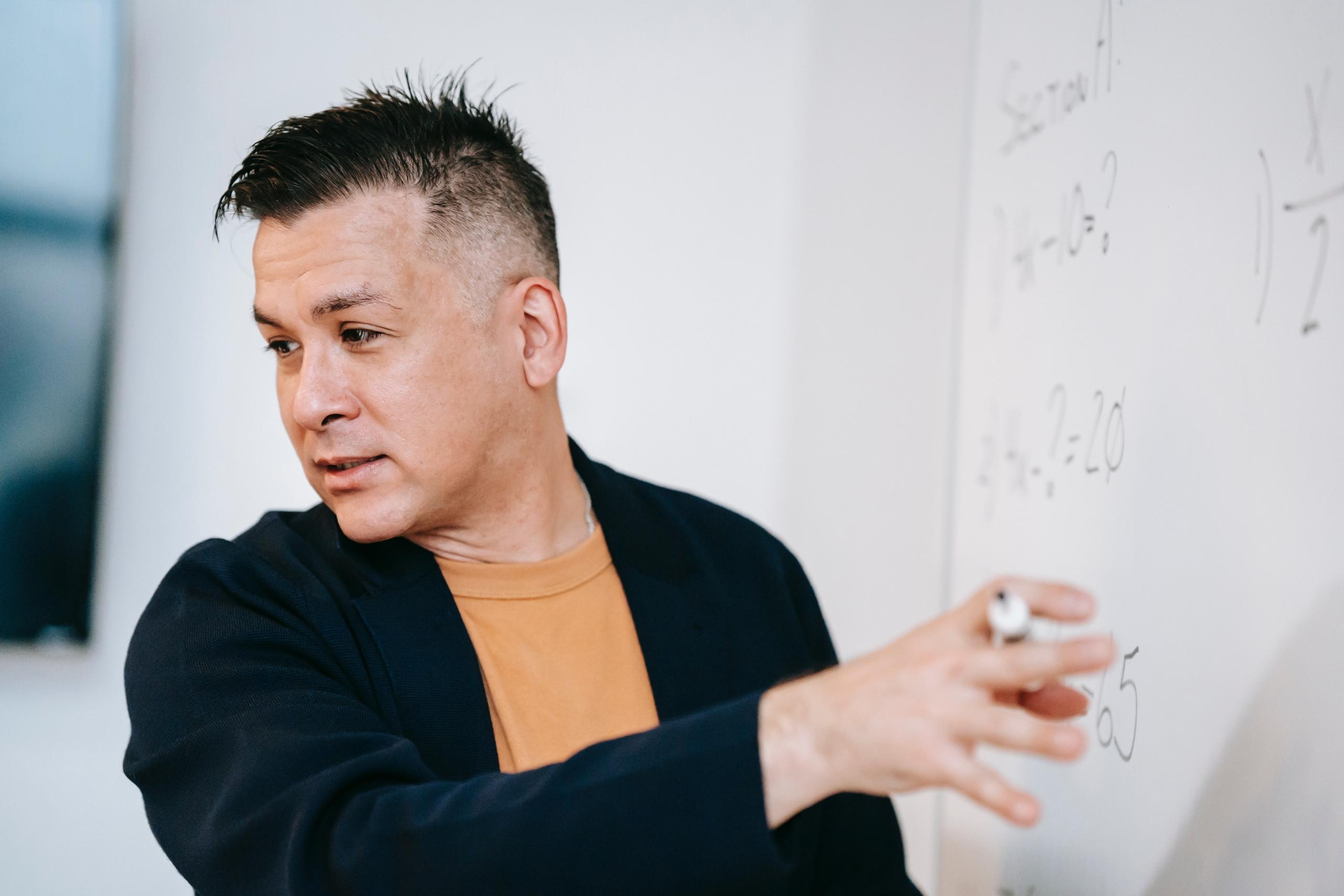 teacher writing down the solution to a maths equation