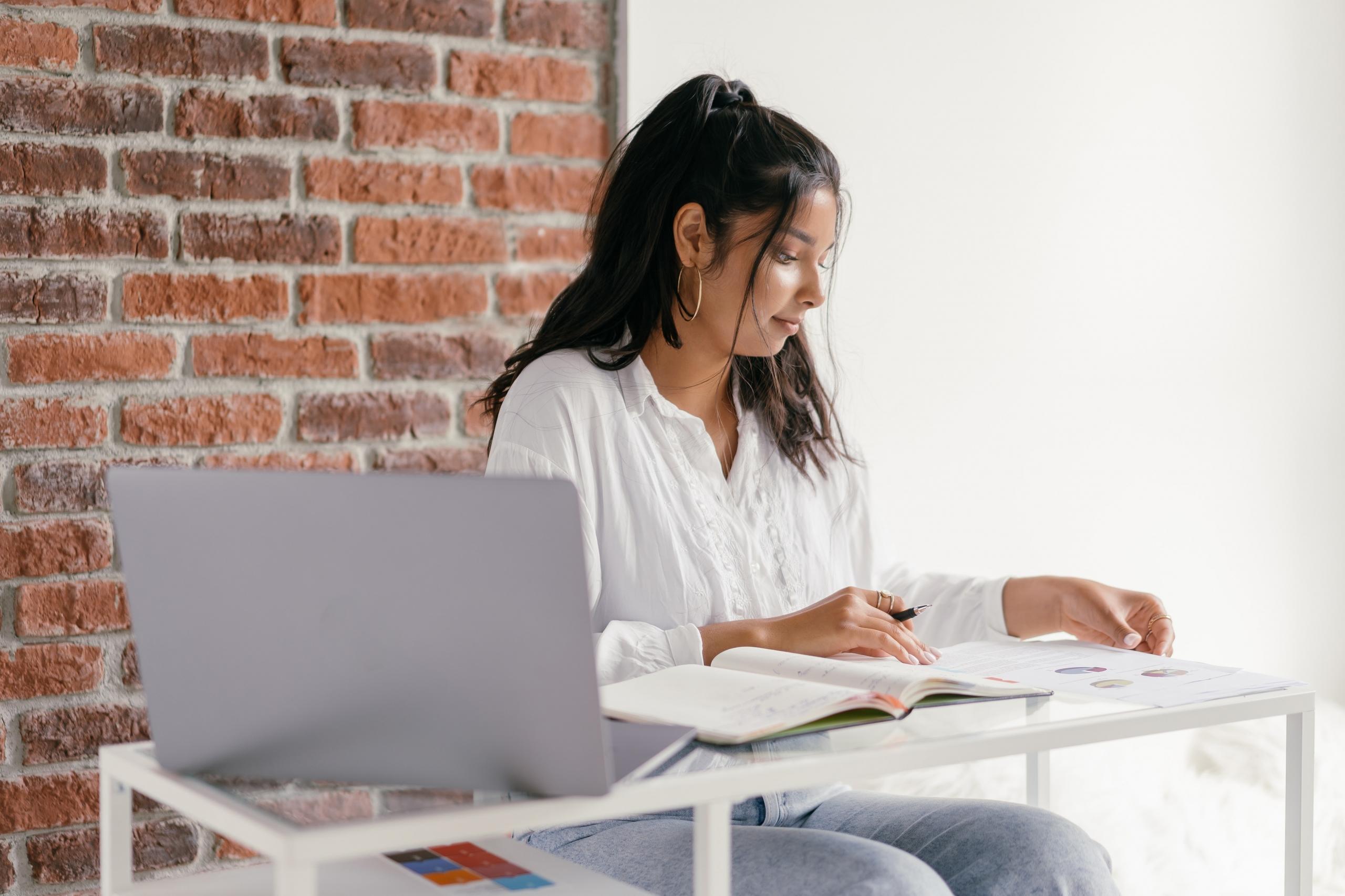 girl doing homework at desk with textbooks and computer