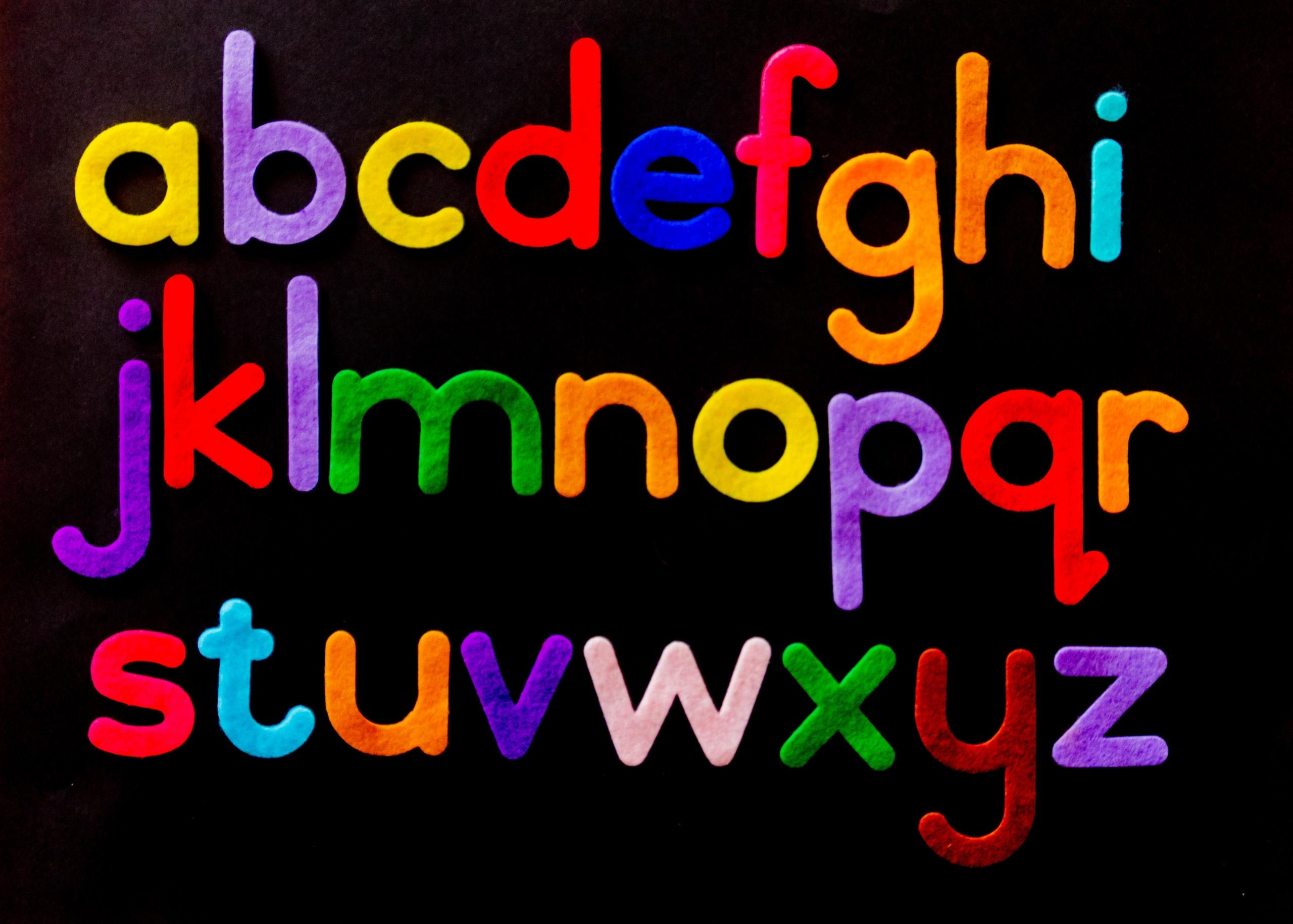 letters of the alphabet made out of felt on black background