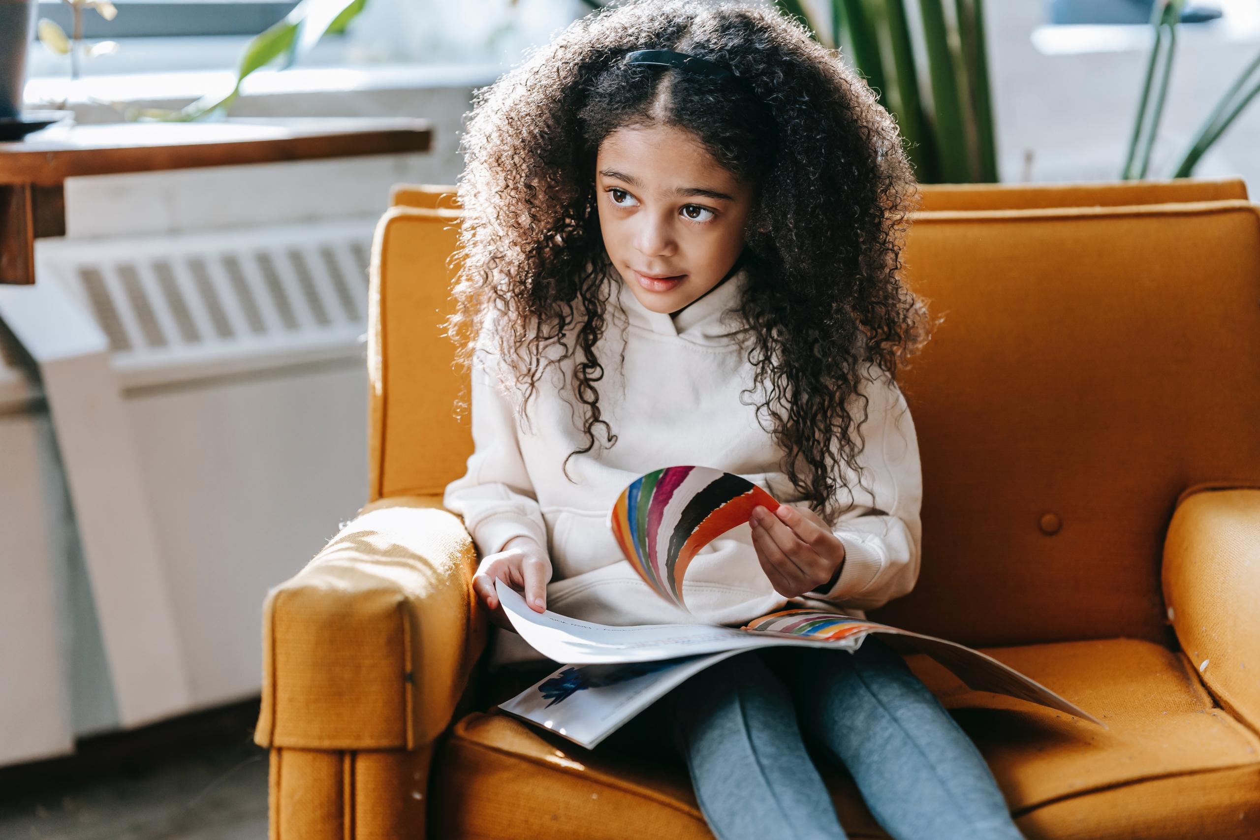 young child sitting down and reading a book