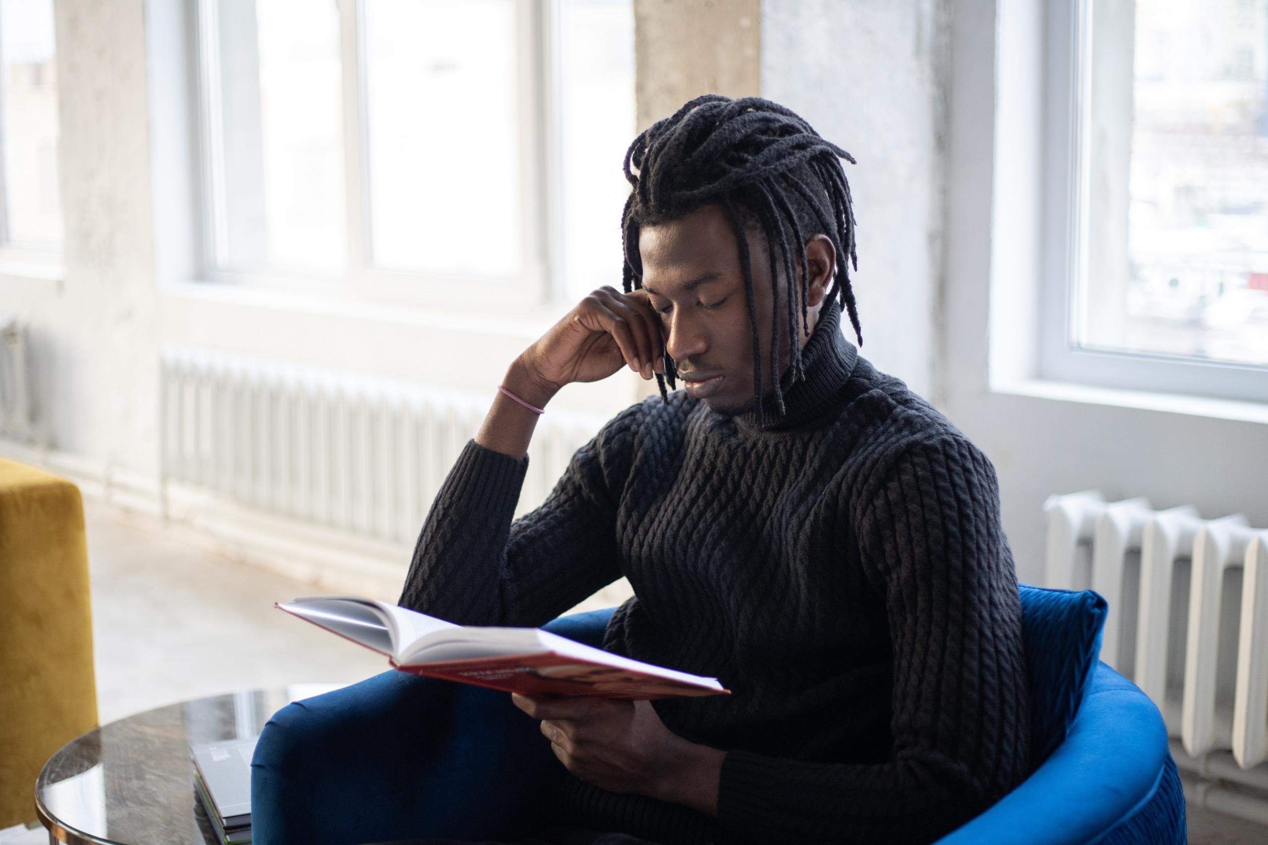 man sitting on a chair reading