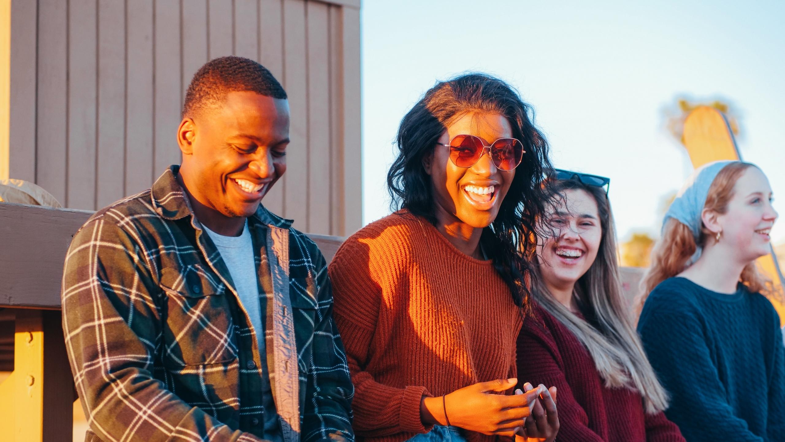 a group of people laughing on the beach