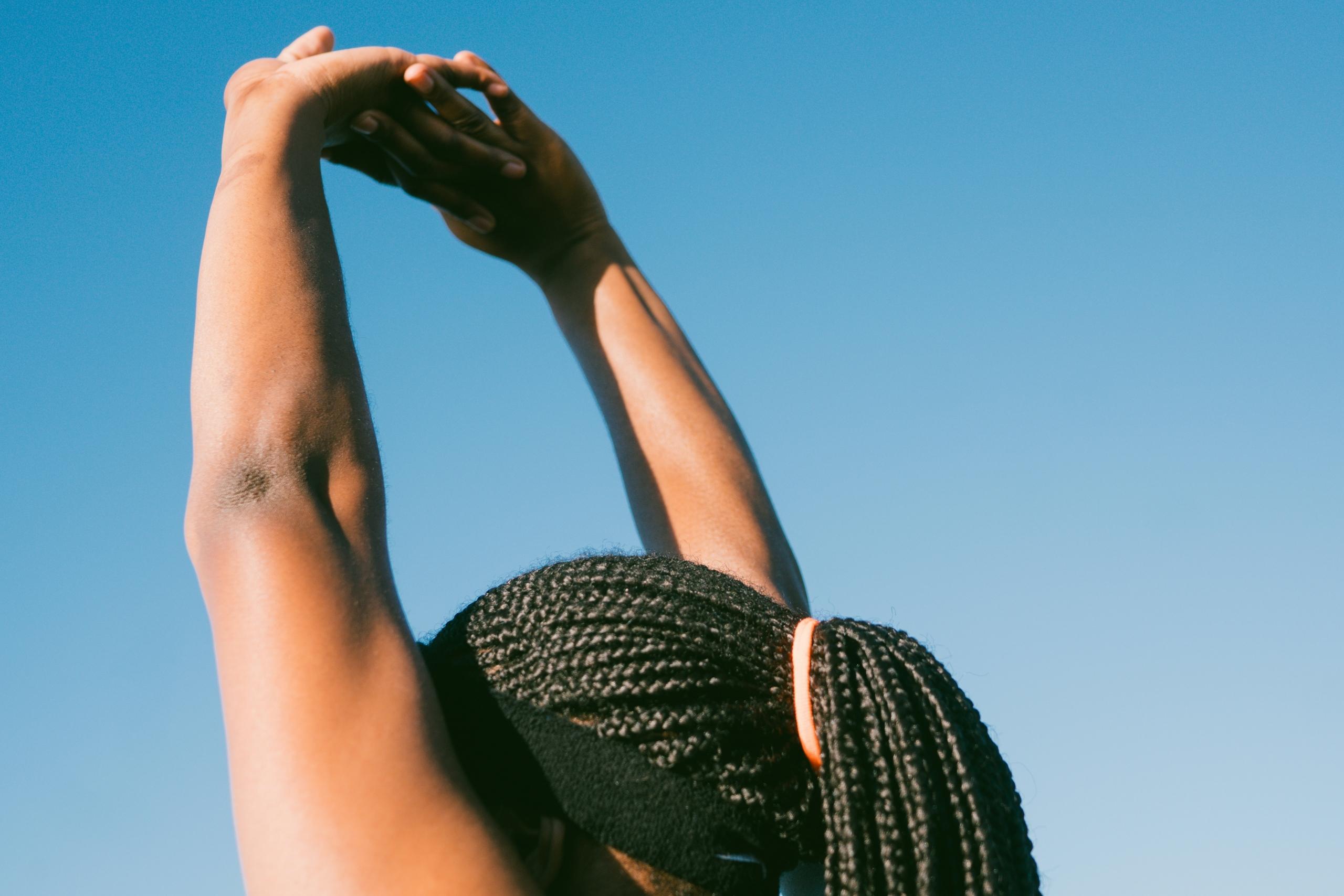sportswoman raising hands above head outdoors