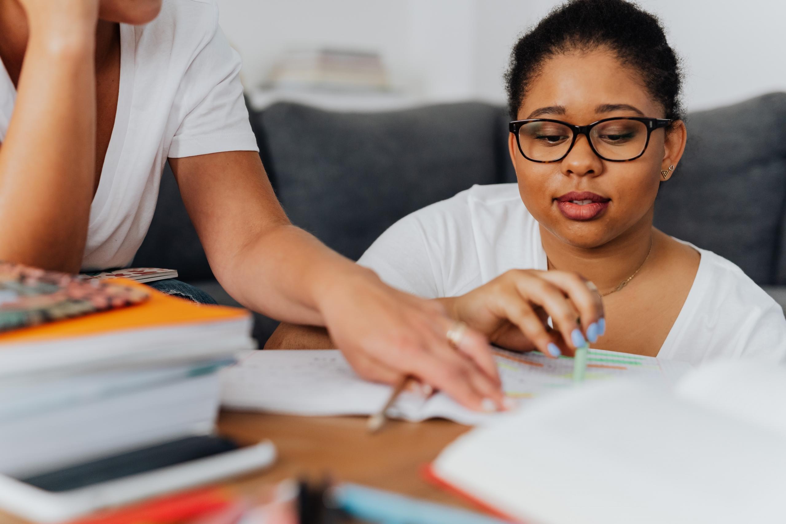 tutor sitting on couch helping student complete an exercise