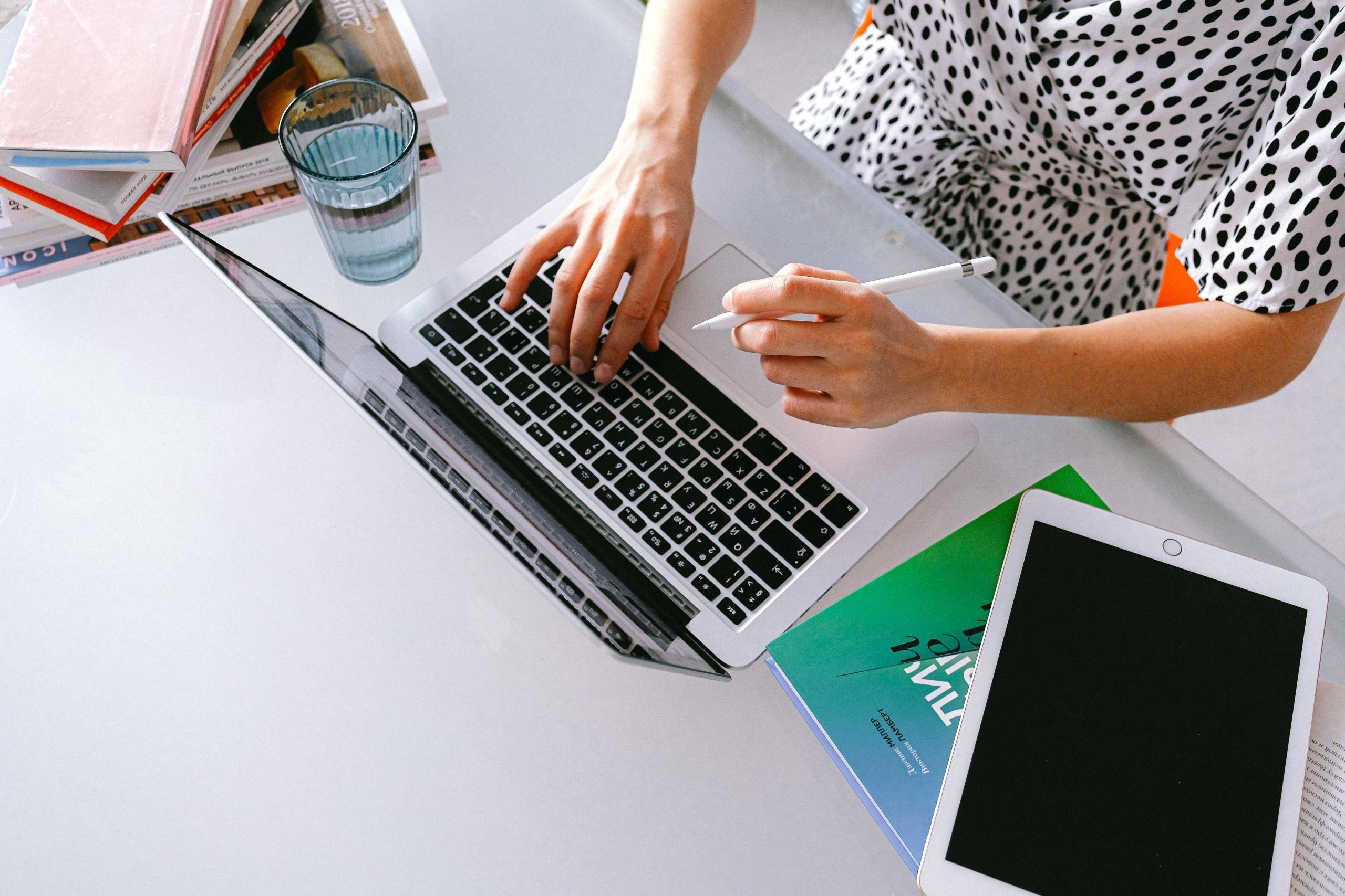 woman at desk typing on laptop keyboard