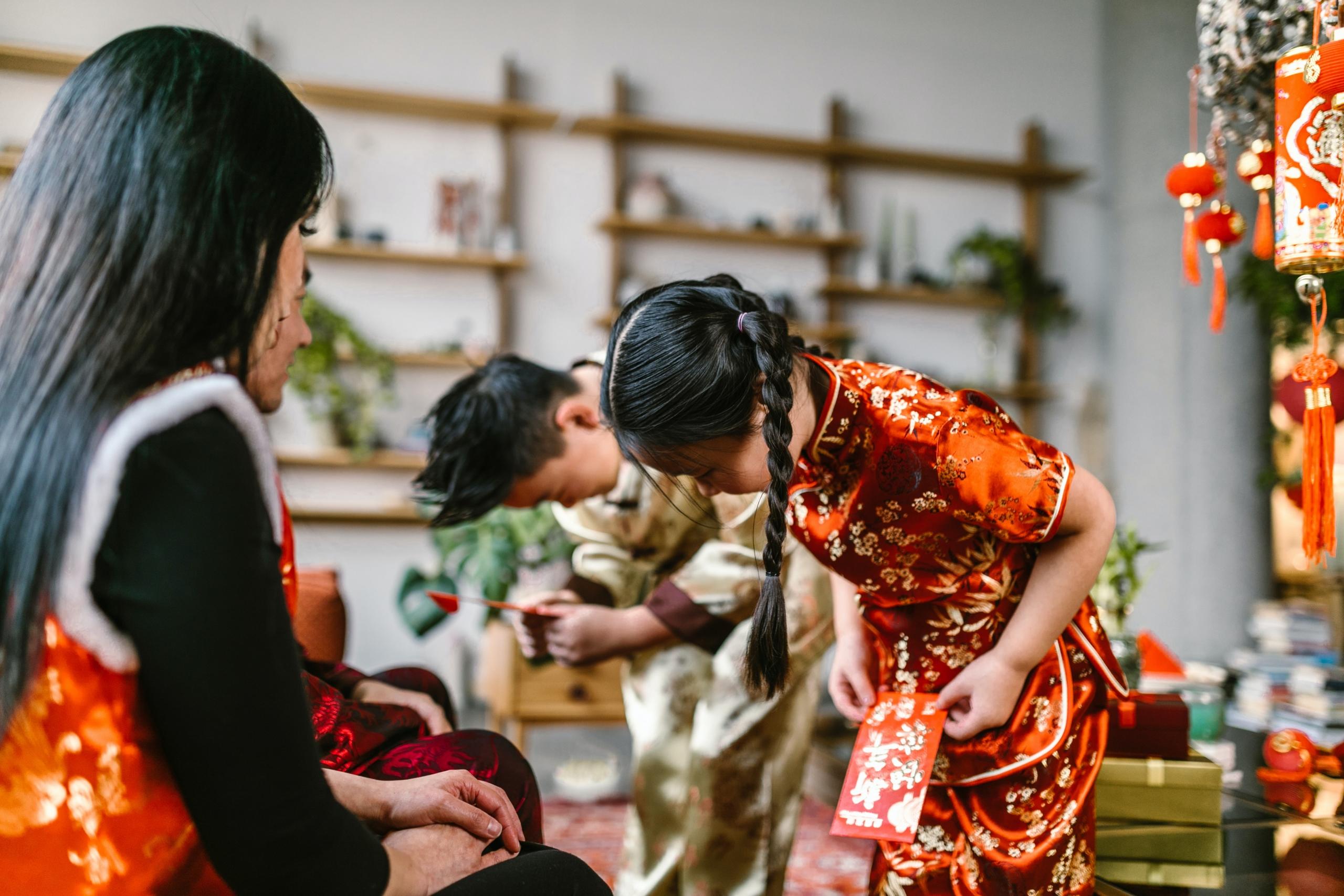 children in traditional Chinese dress bowing to elders