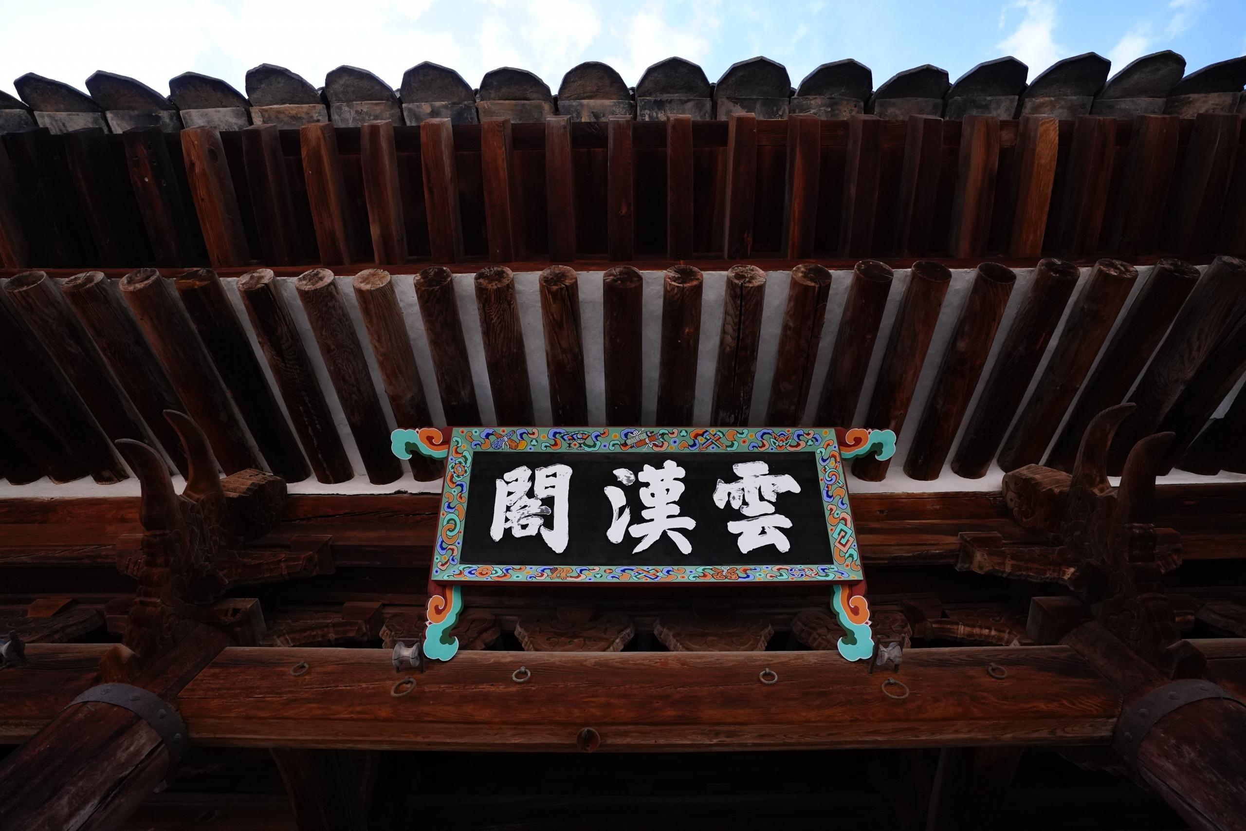 Korean writing on a board attached to traditional temple in Korea