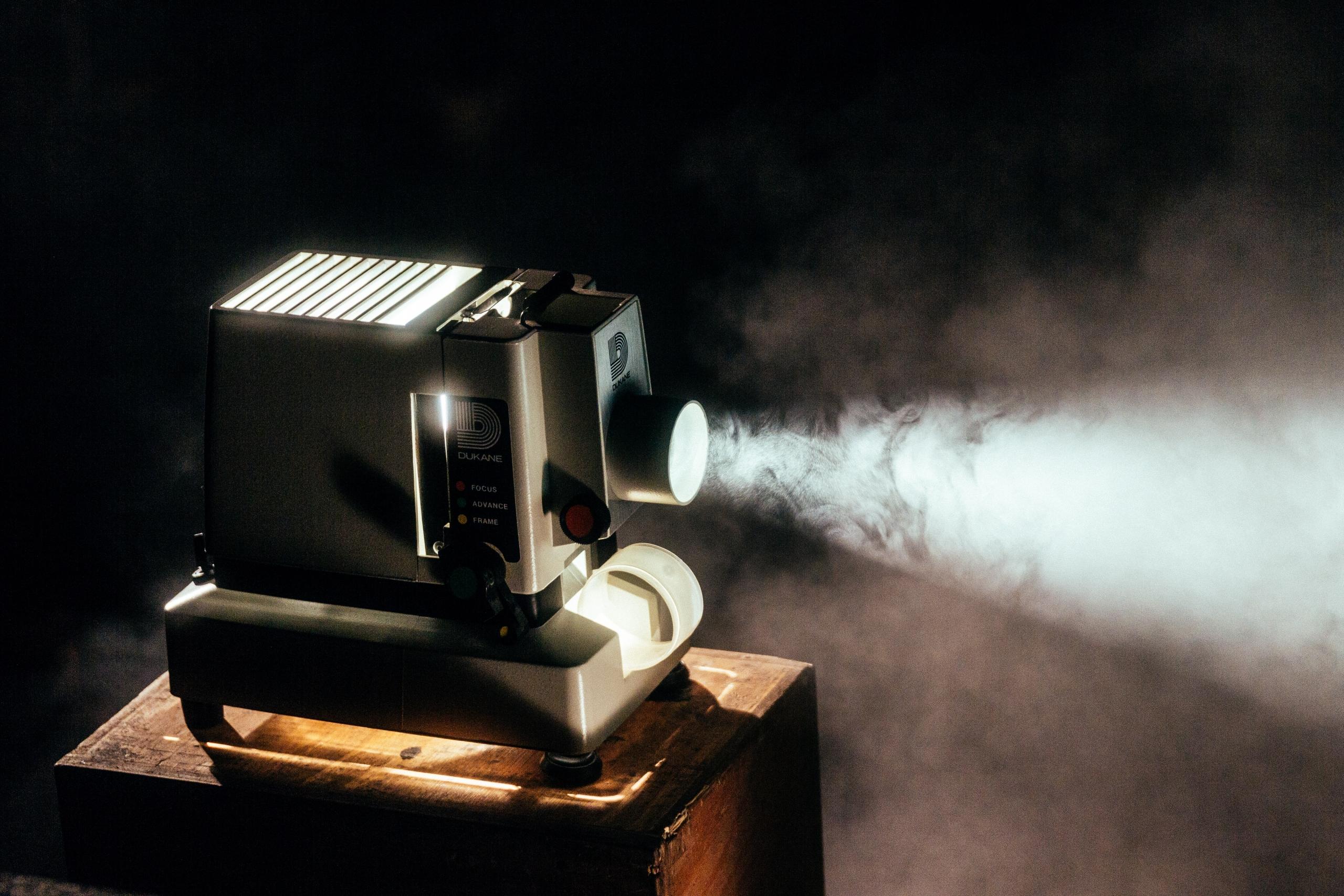 movie projector on a table in a dark, smoked filled room