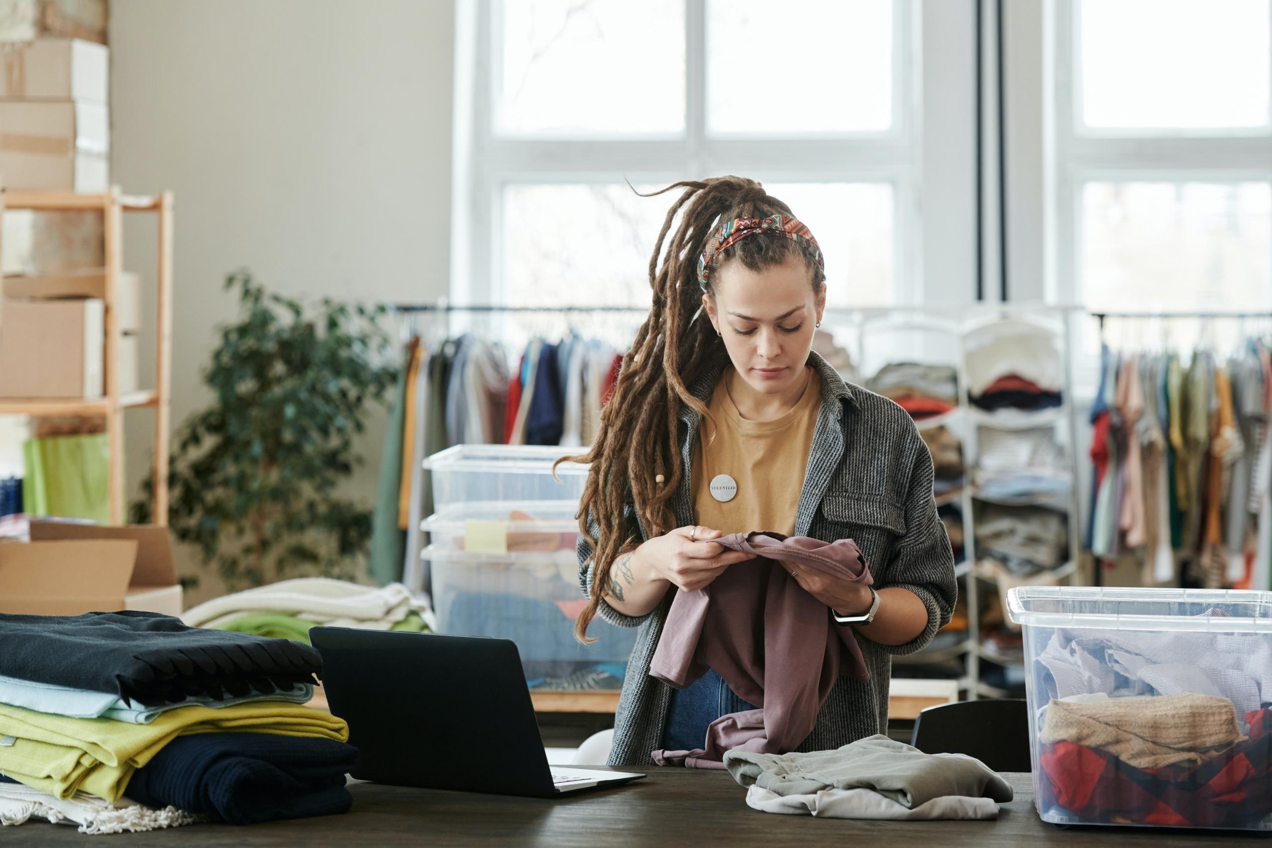woman working behind counter in secondhand clothing store