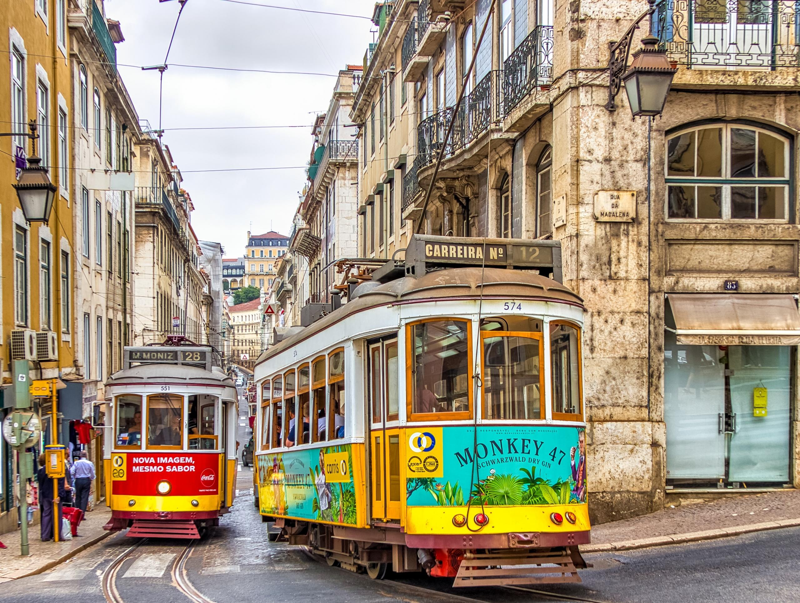 colourful trams winding around corner in Portuguese street