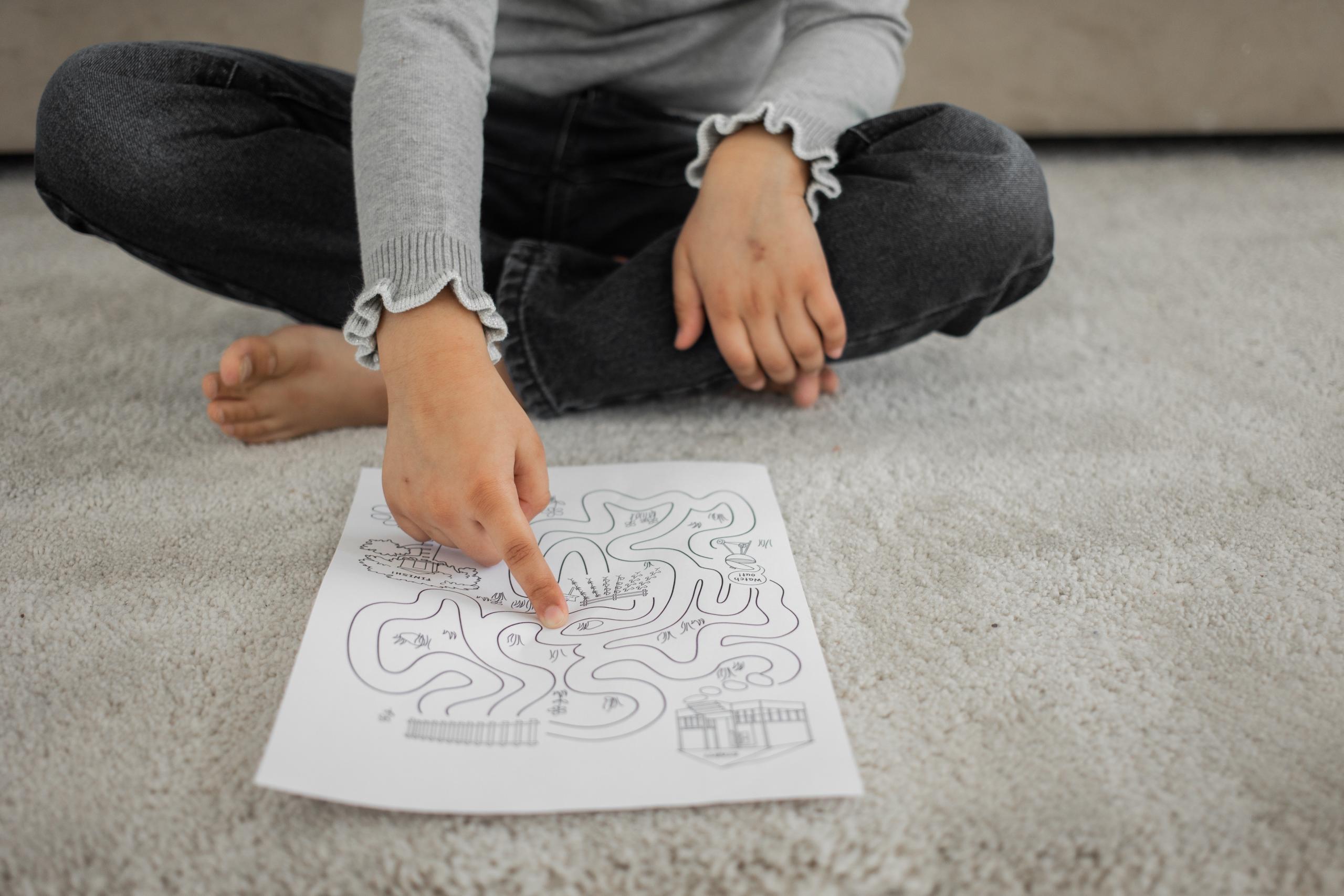 child tracing with finger on sheet of paper