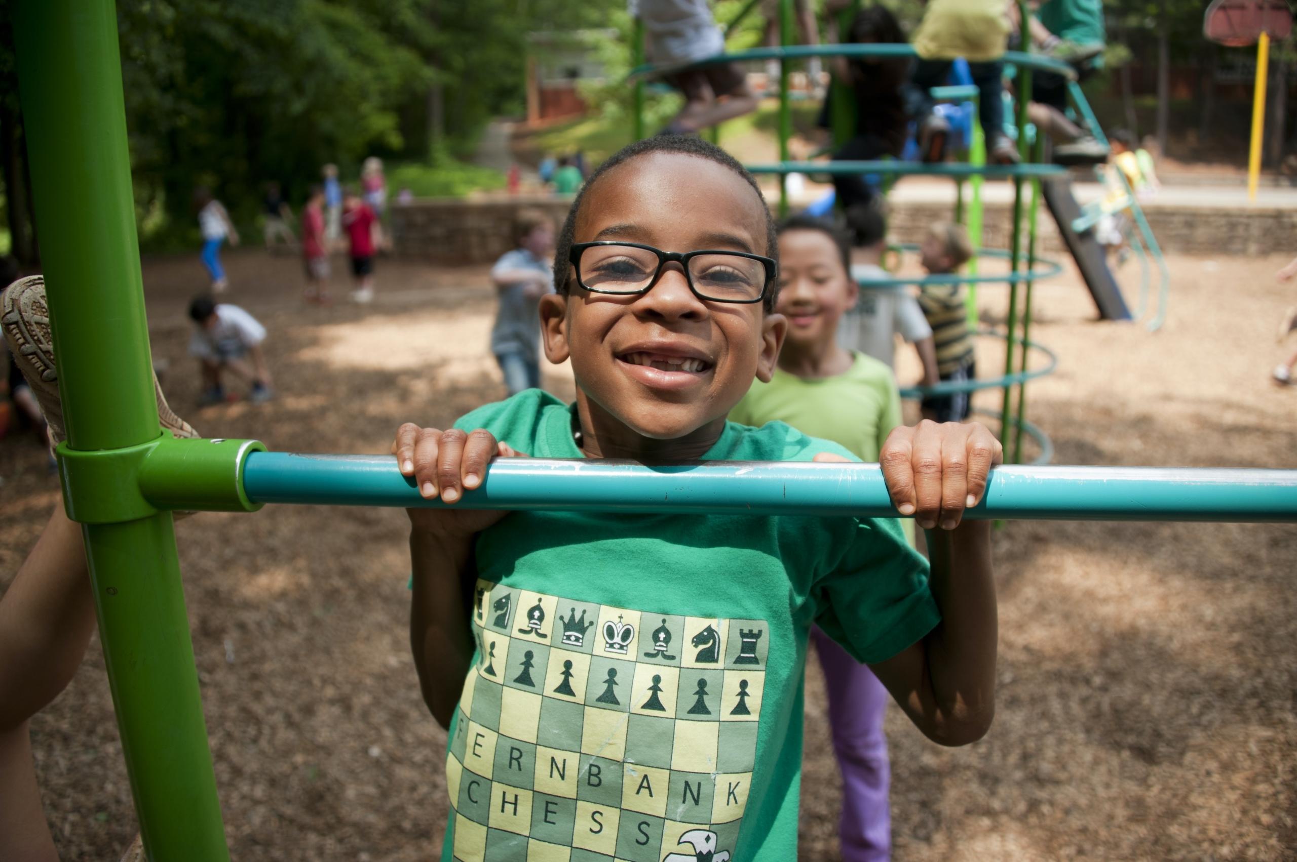 boy using climbing frame in playground
