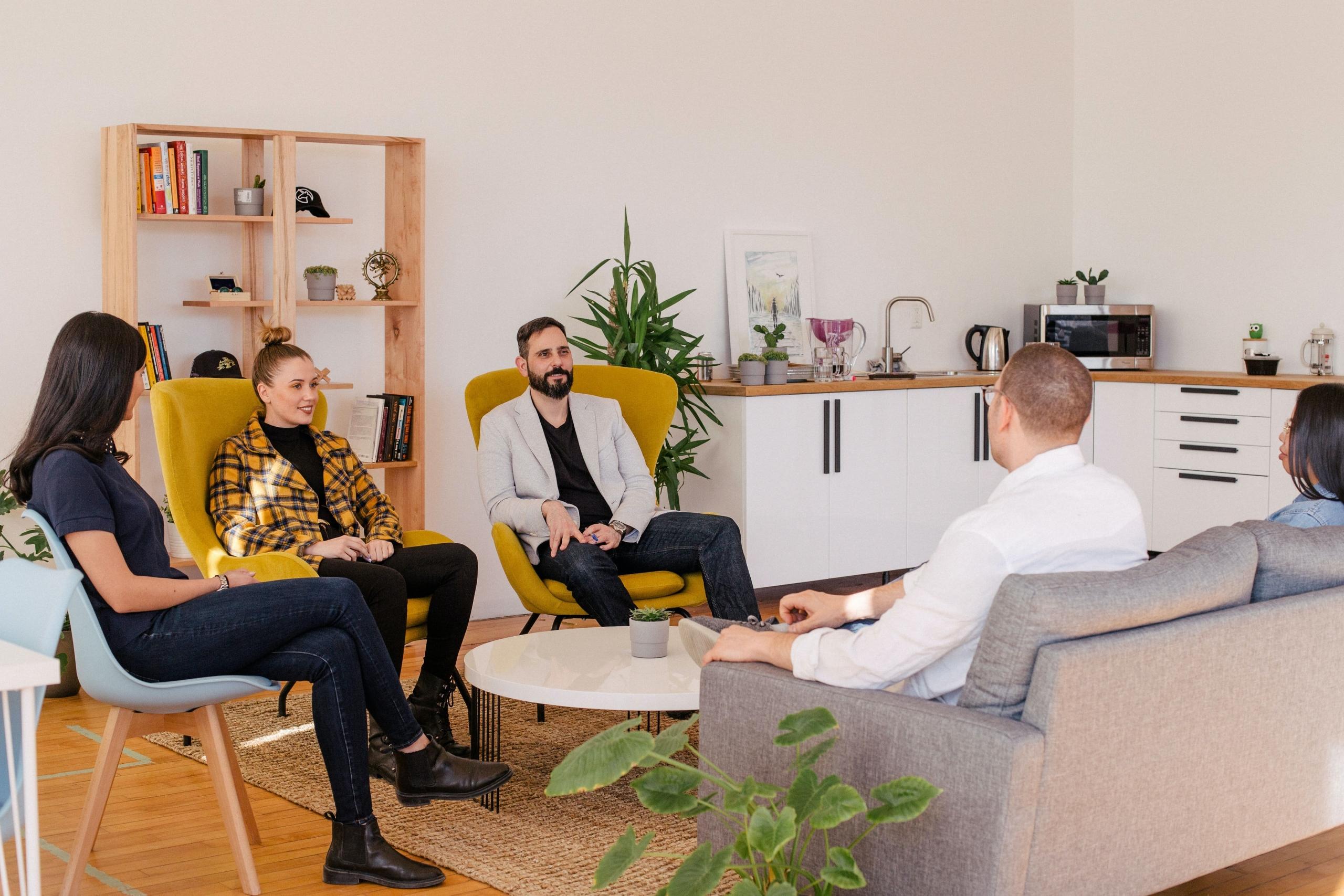 group of people sitting around a coffee table in an office