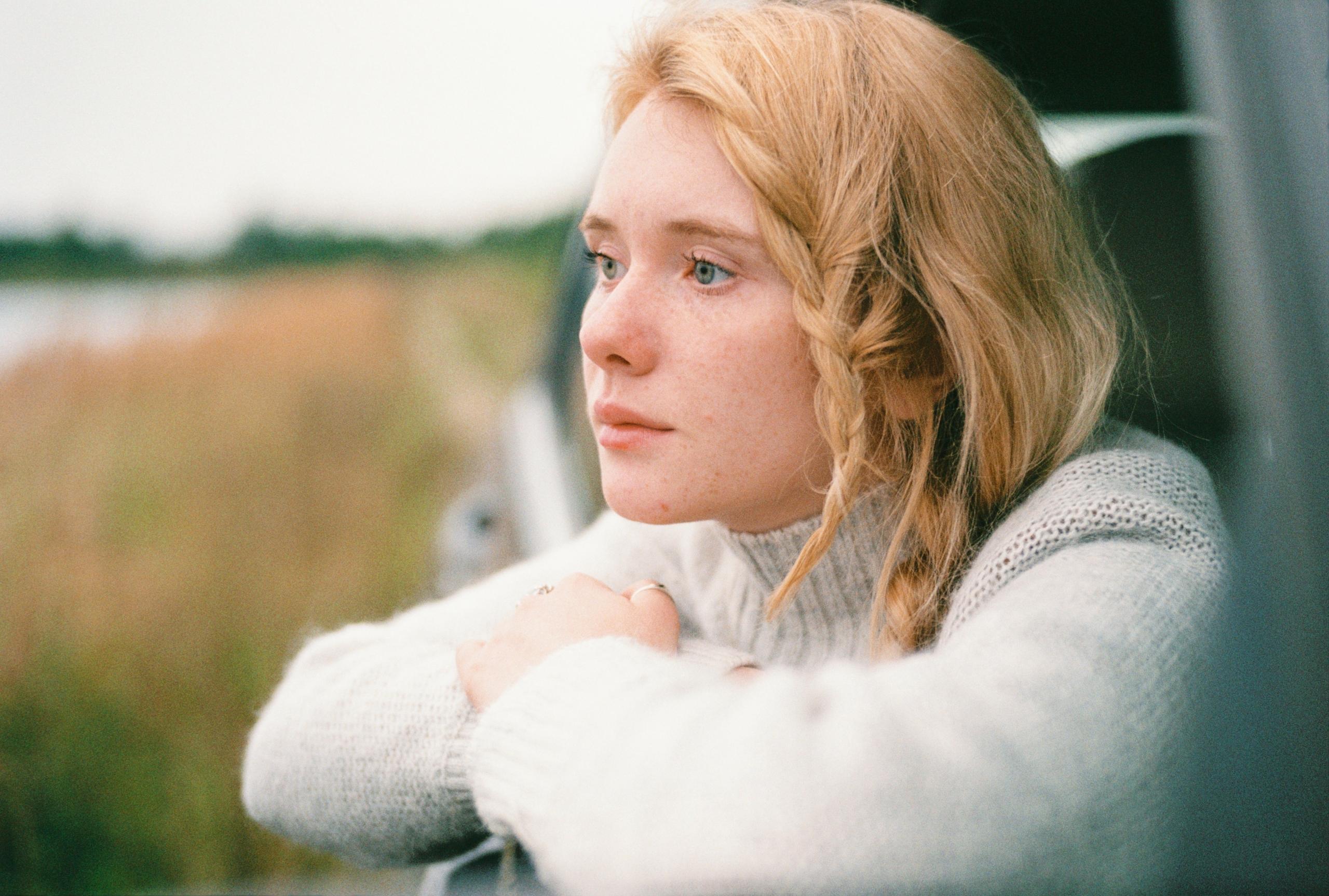 woman thinking deeply while looking out at nature scene