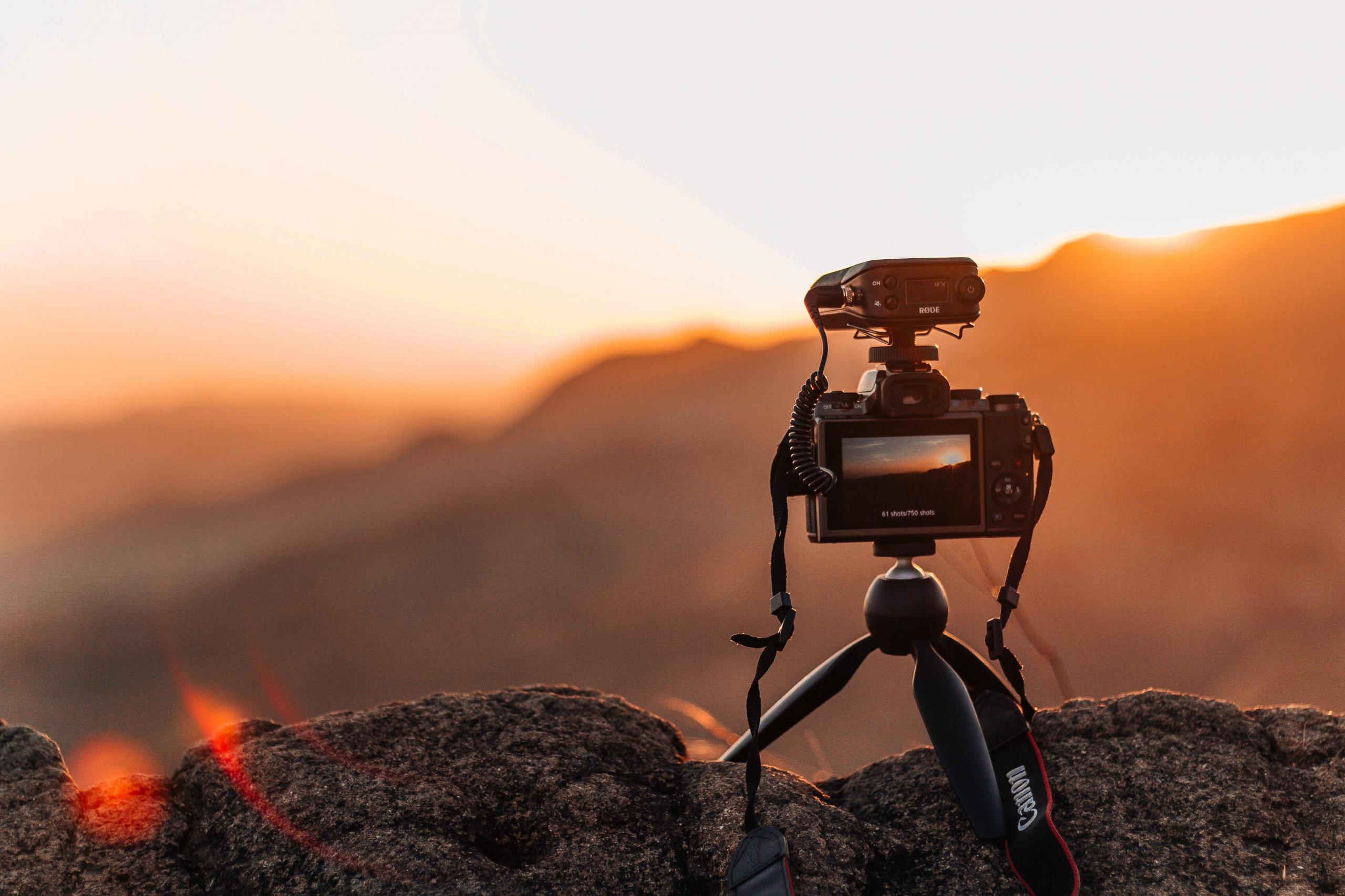digital camera on tripod, placed on Rocky Mountain at sunrise