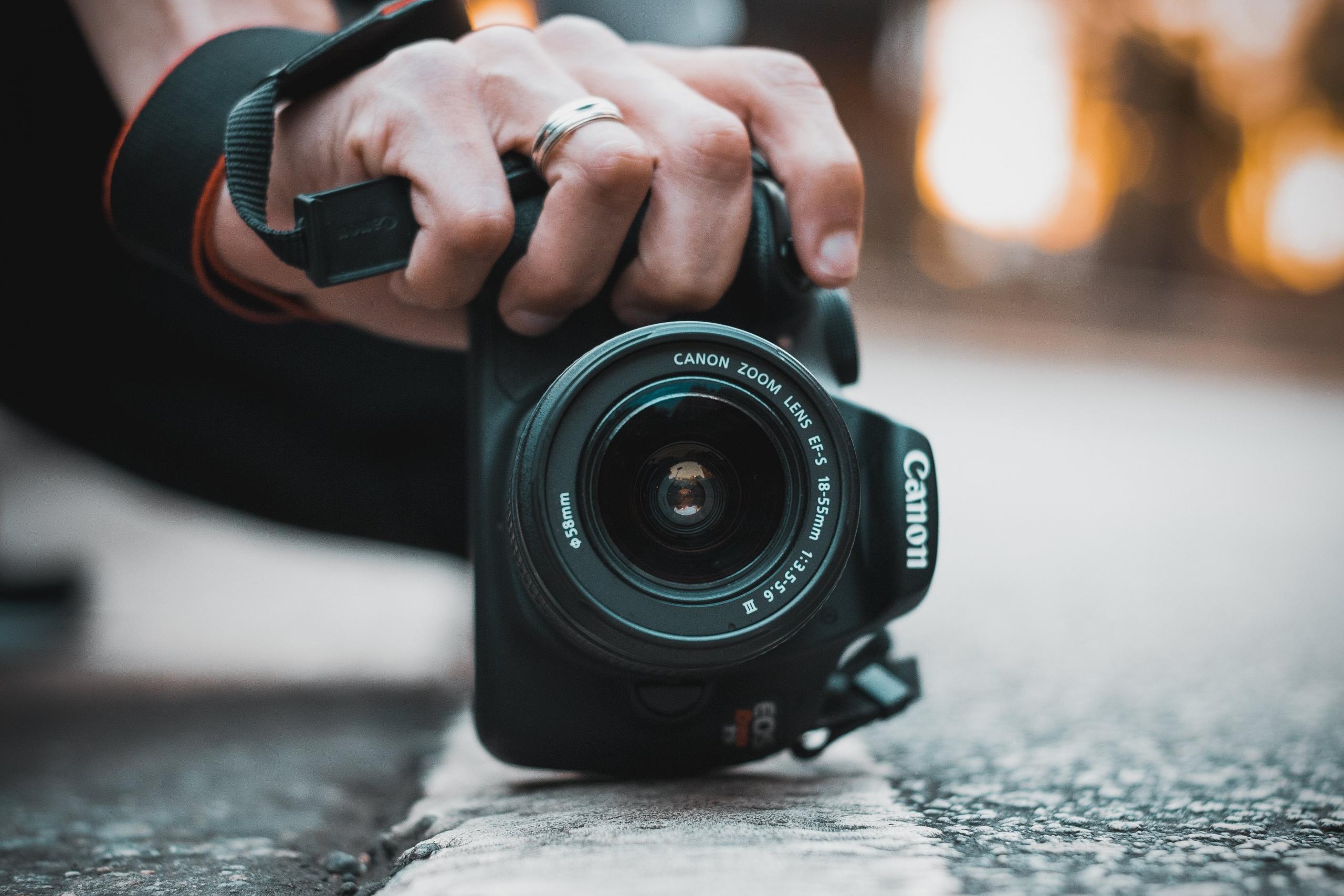photography holding camera down to the markings on the surface of a tarred road