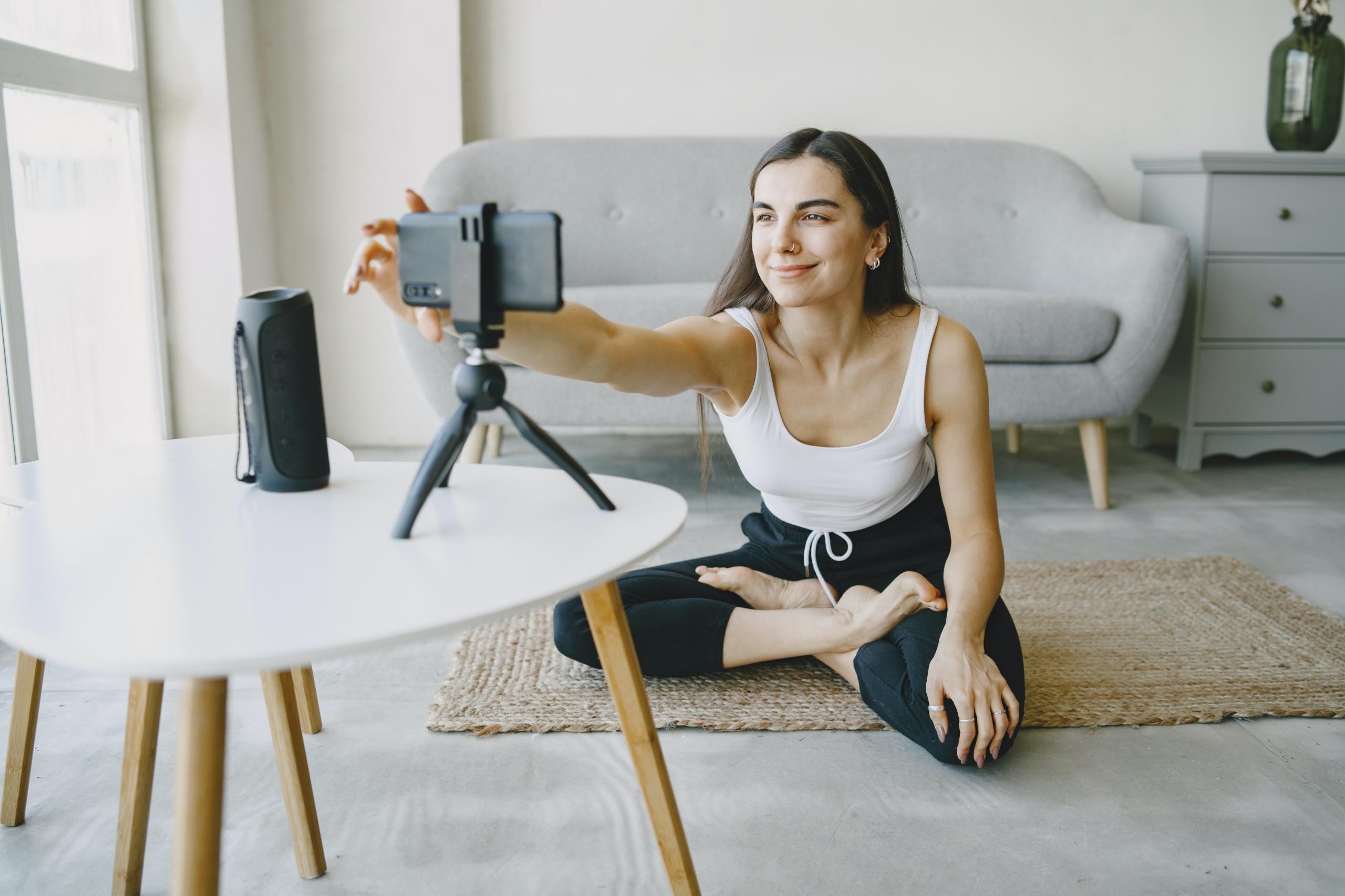 yoga teacher setting up camera for online yoga class
