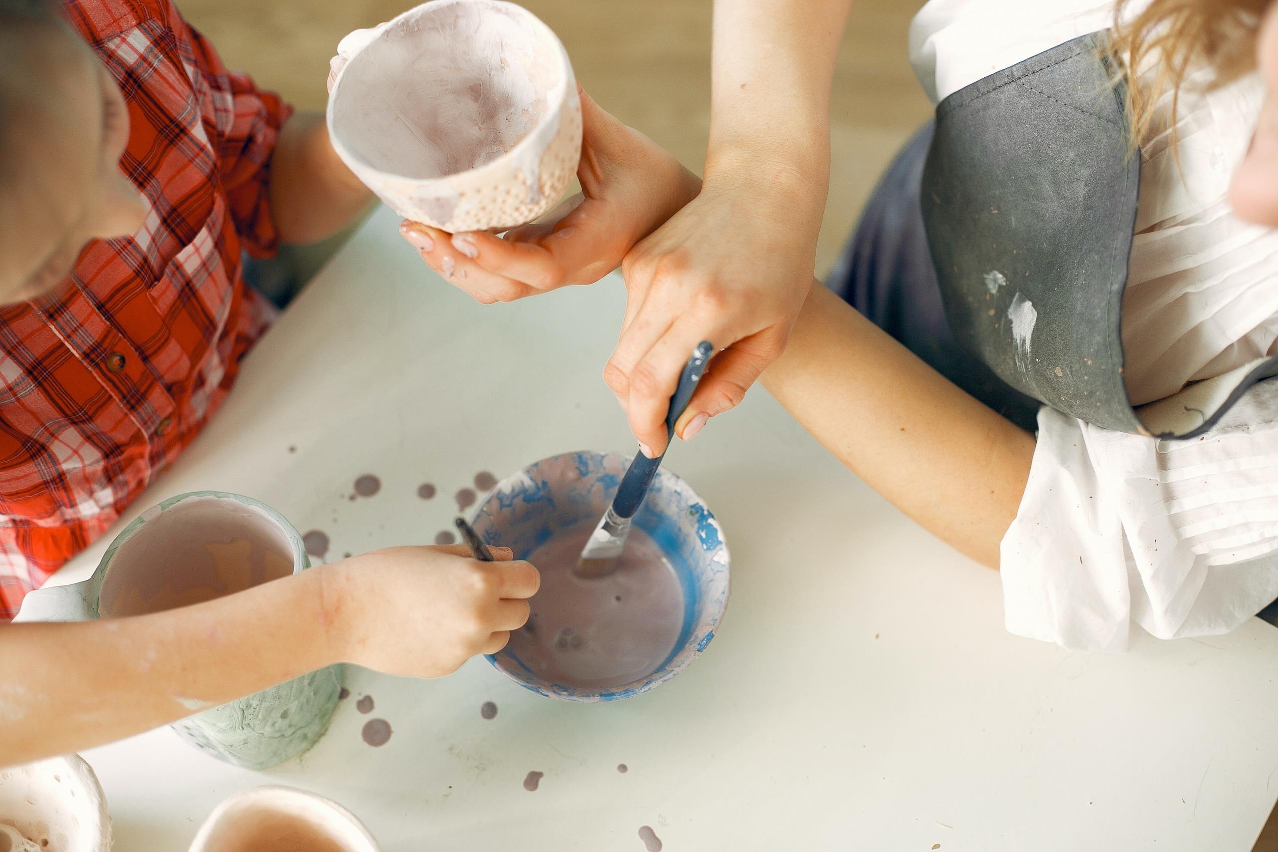 student and pottery teacher painting ceramics
