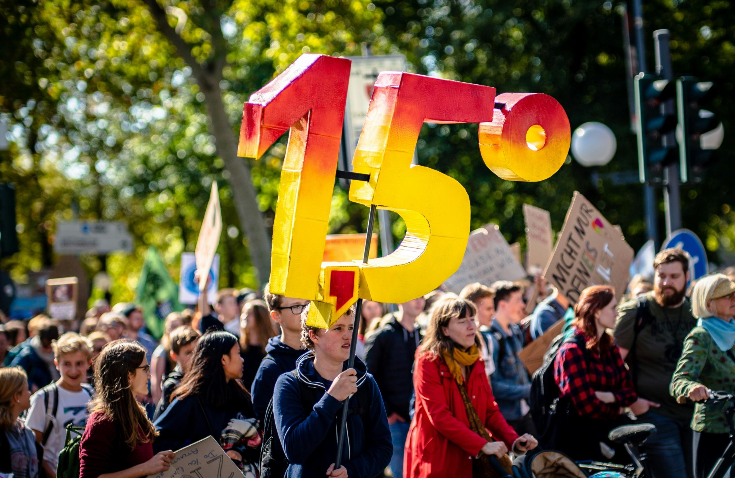 person holding up 3D sign during climate change protest