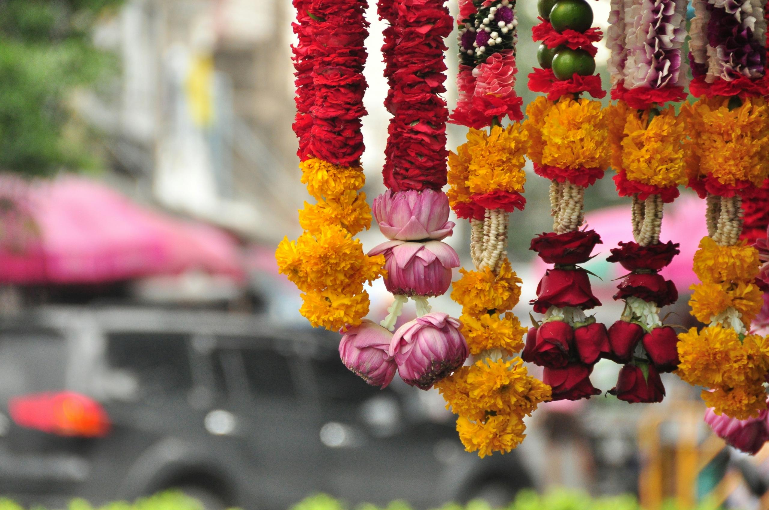 garlands made of red, pink and orange flowers hanging