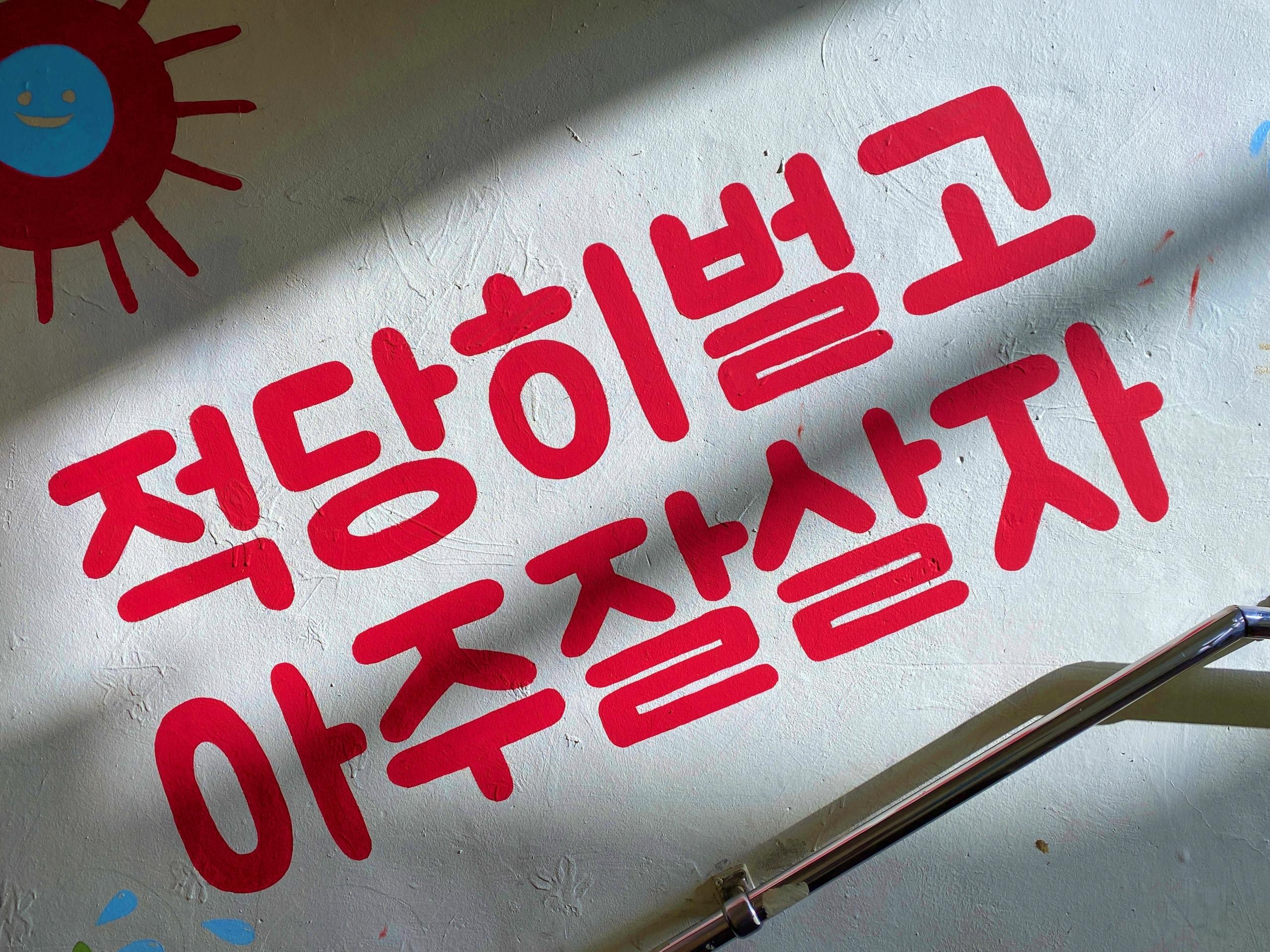 message painted in red alongside staircase using Hangul