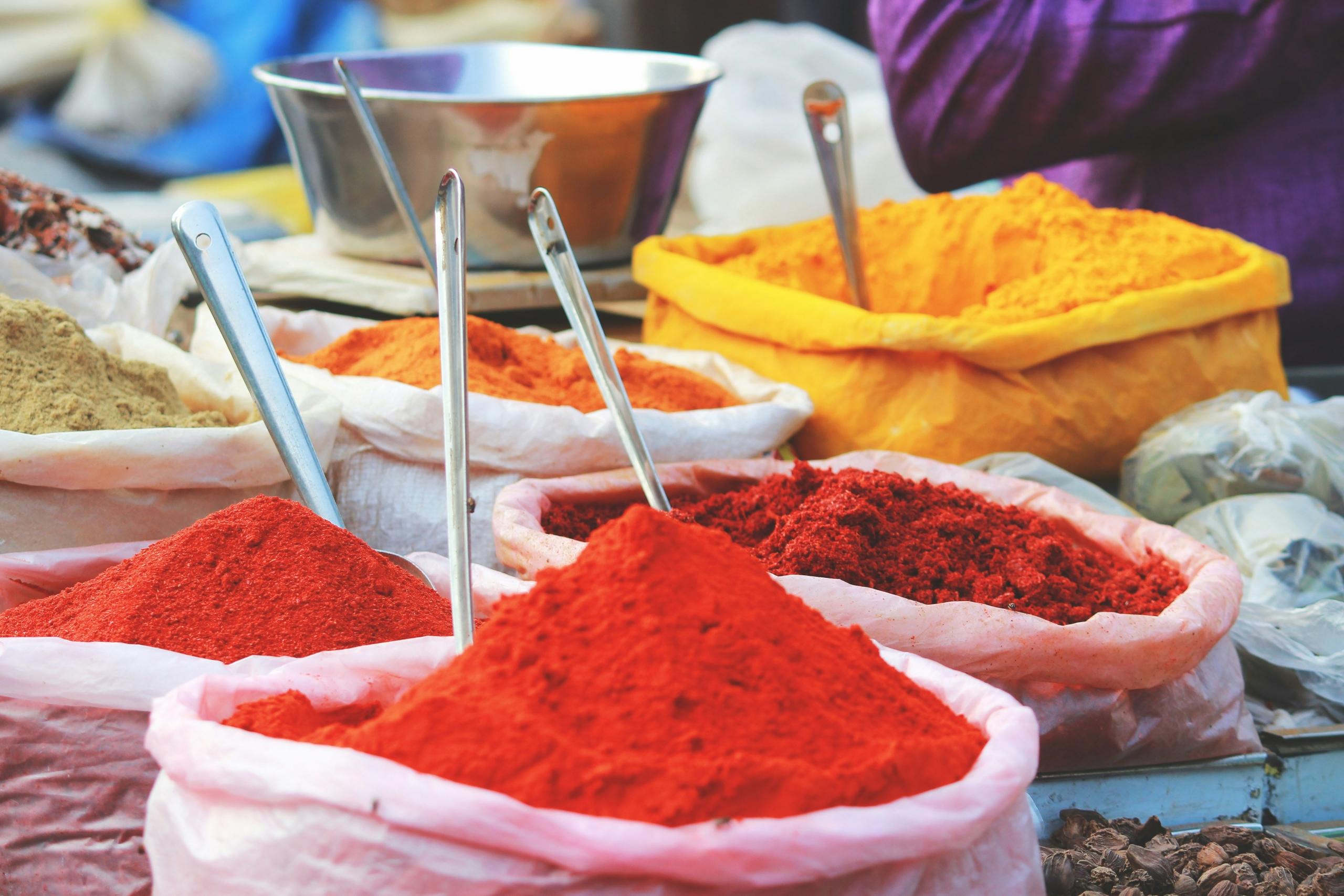 brightly coloured ground spices on display in marketplace in India