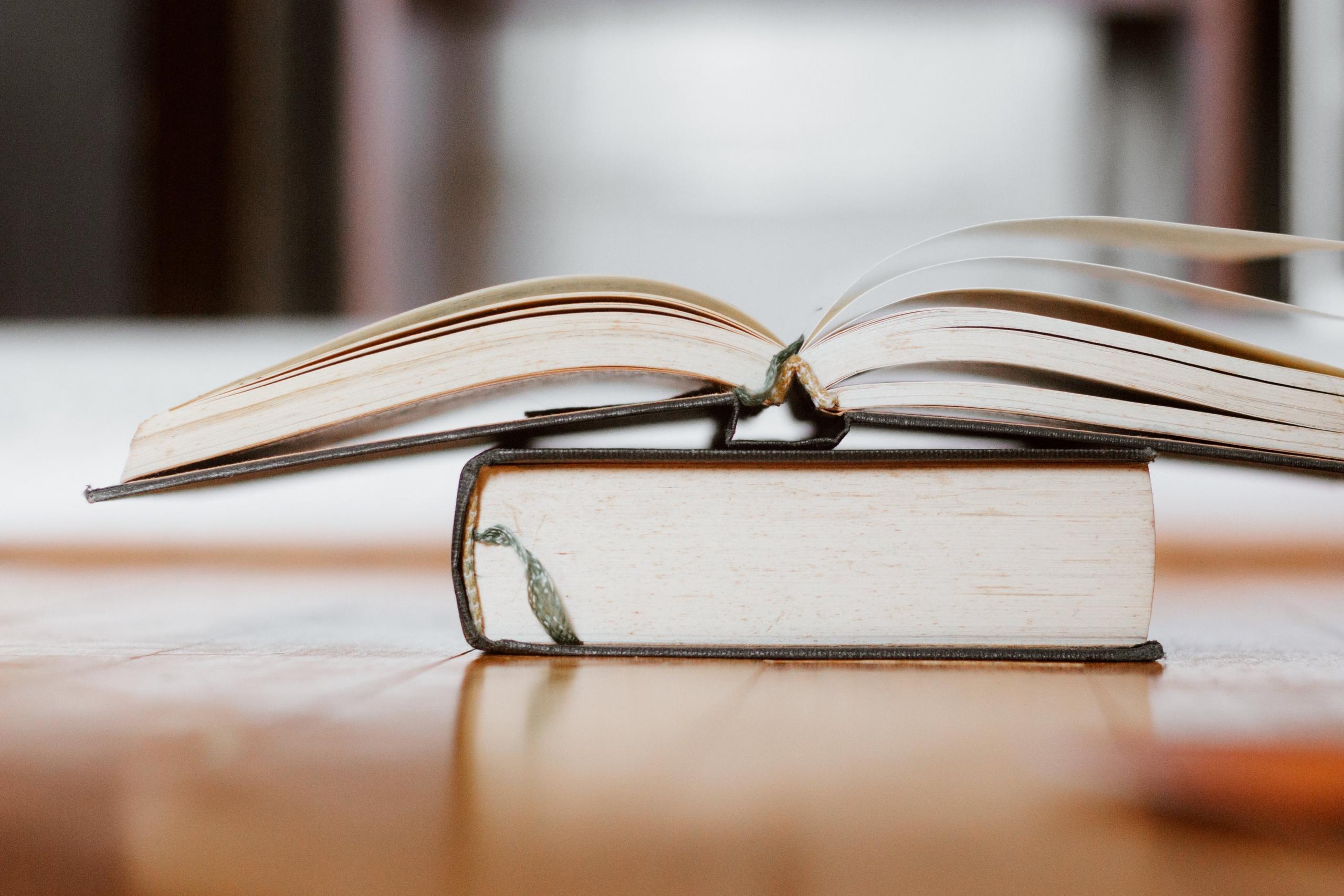 an open book stacked on top of a closed book