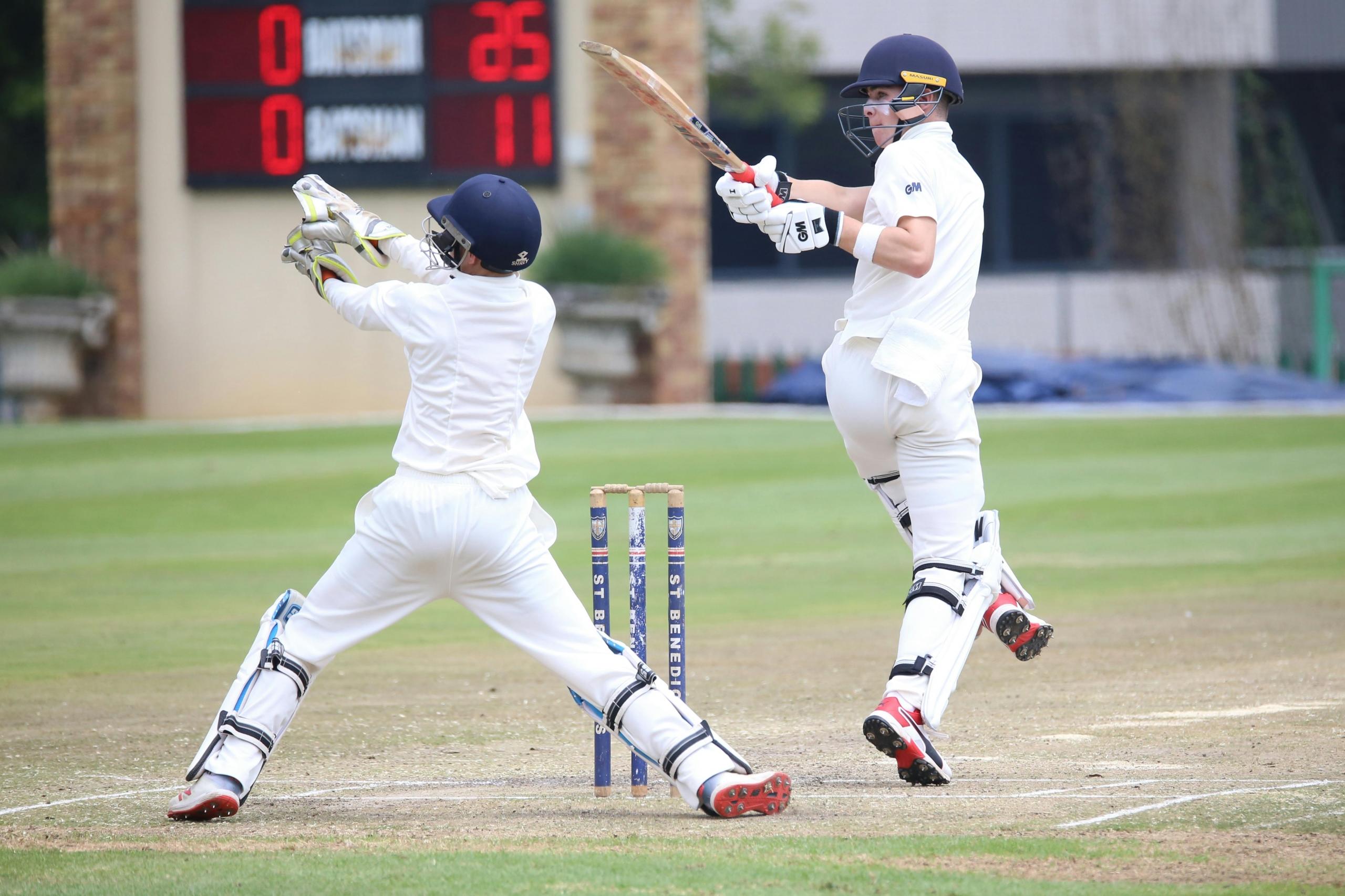 junior cricket batsman and wicket keeper on cricket oval