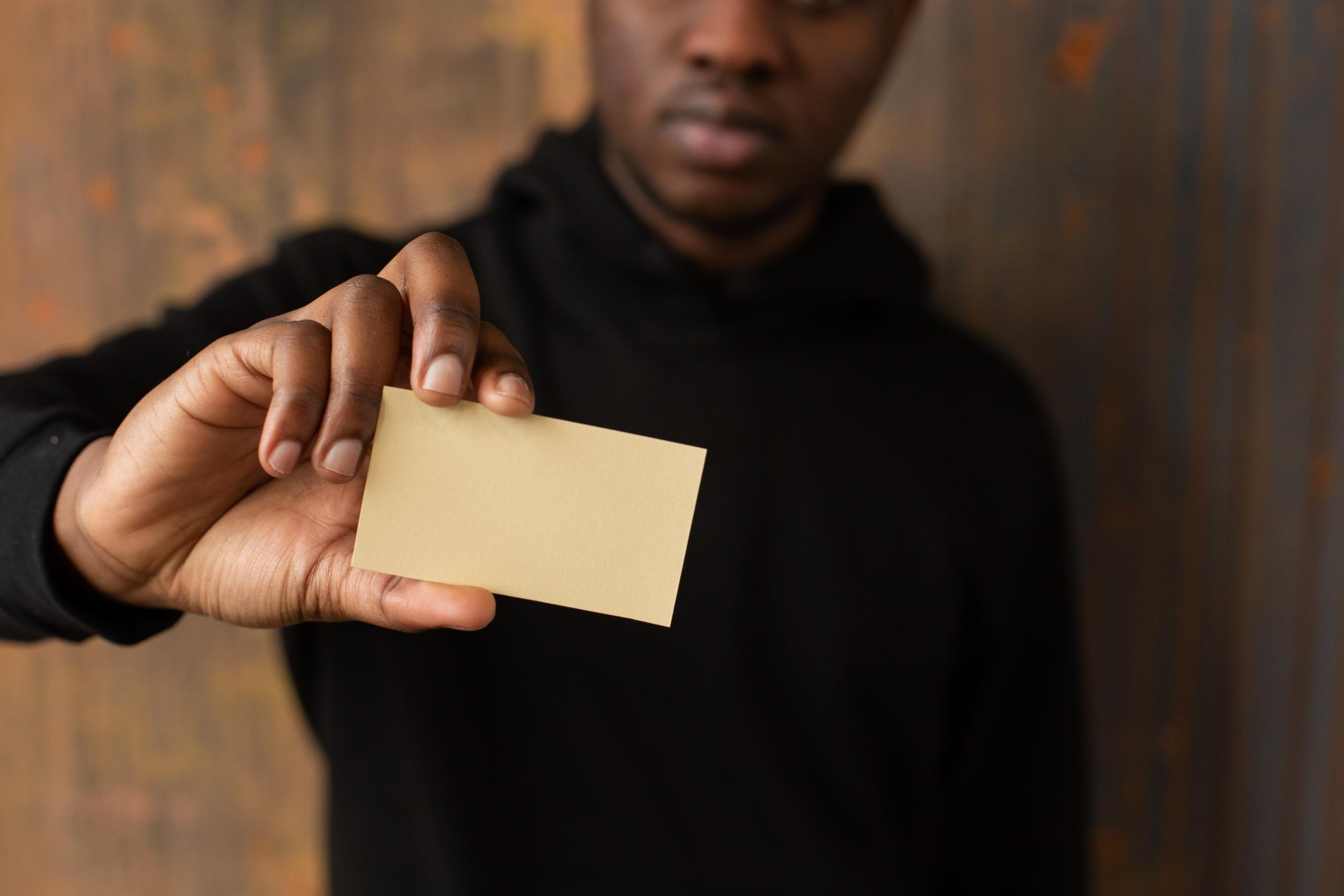 man holding up yellow card and reading the information it contains