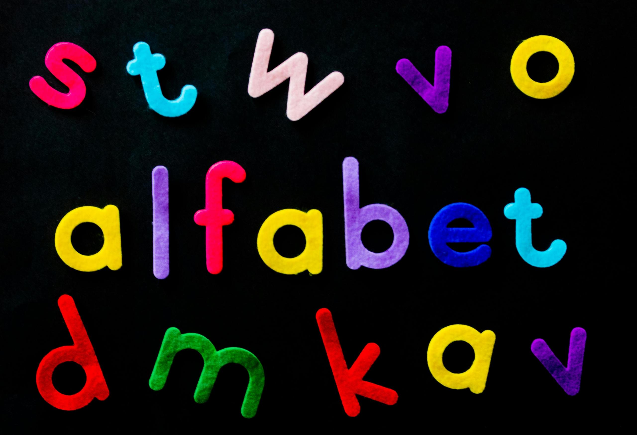afrikaans word alfabet written in multicoloured felt on black