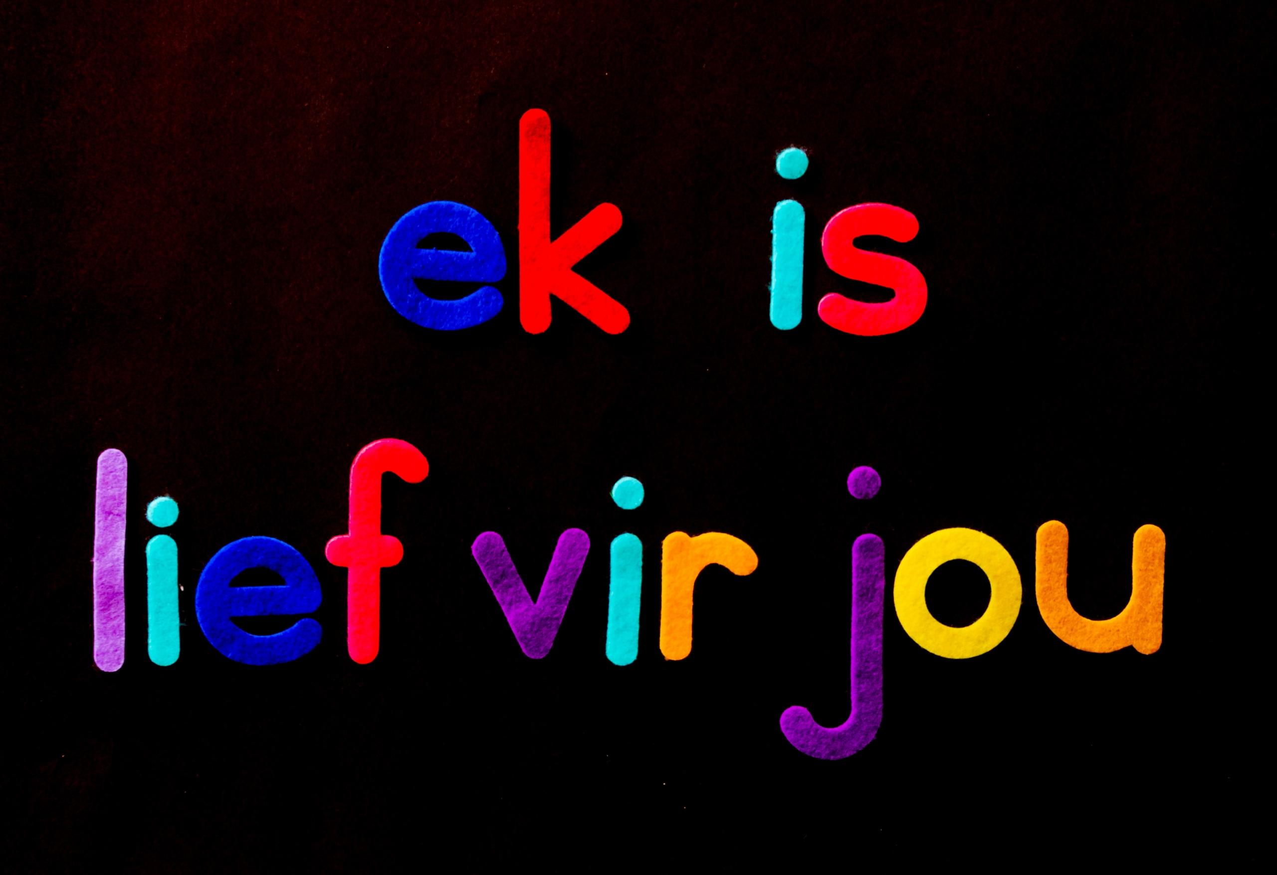 afrikaans phrase ek is lief vir jou written in multicoloured felt on black