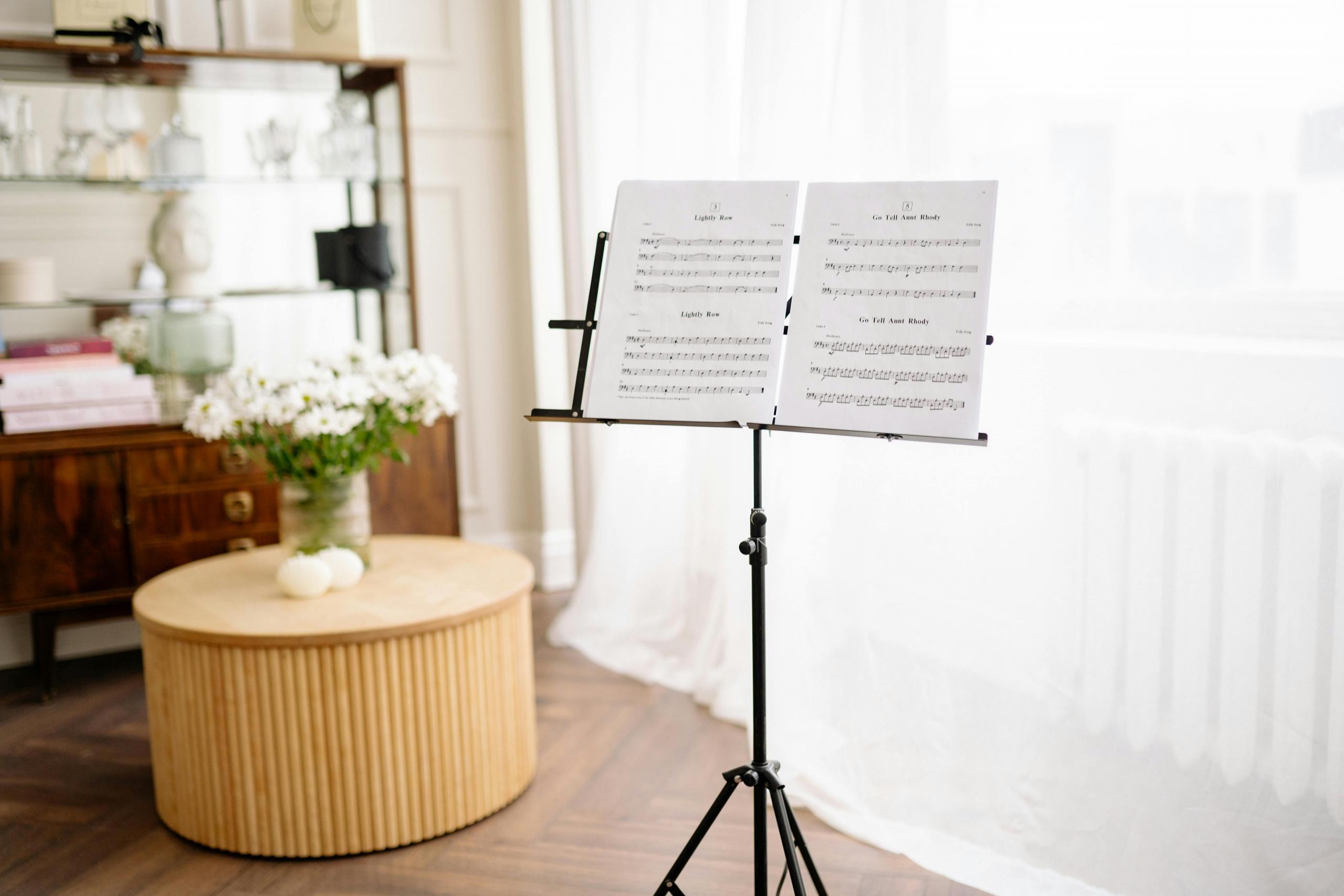 musical score presented on a music stand in front of window with sheer curtains