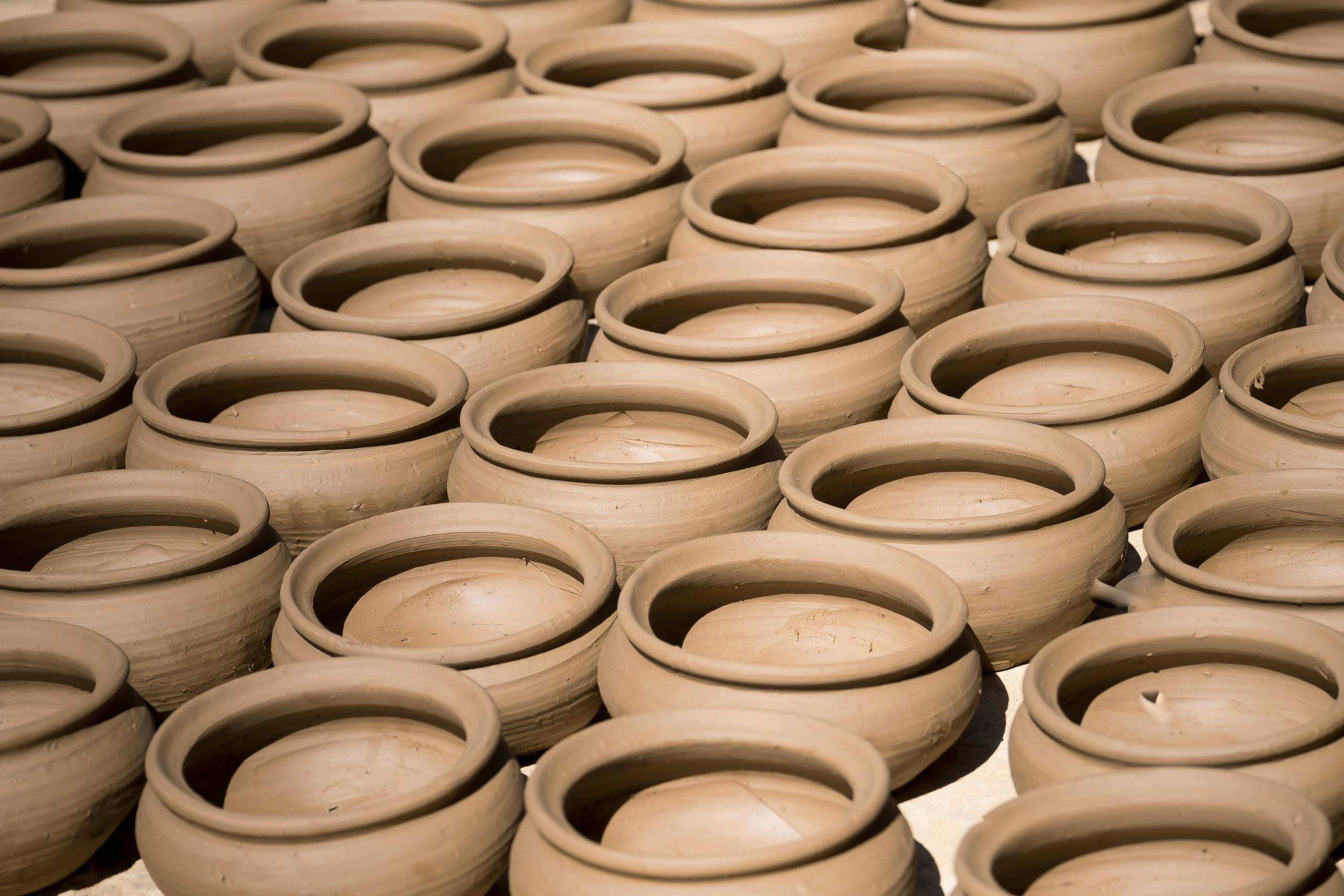 a selection unpainted clay pots laid out in rows