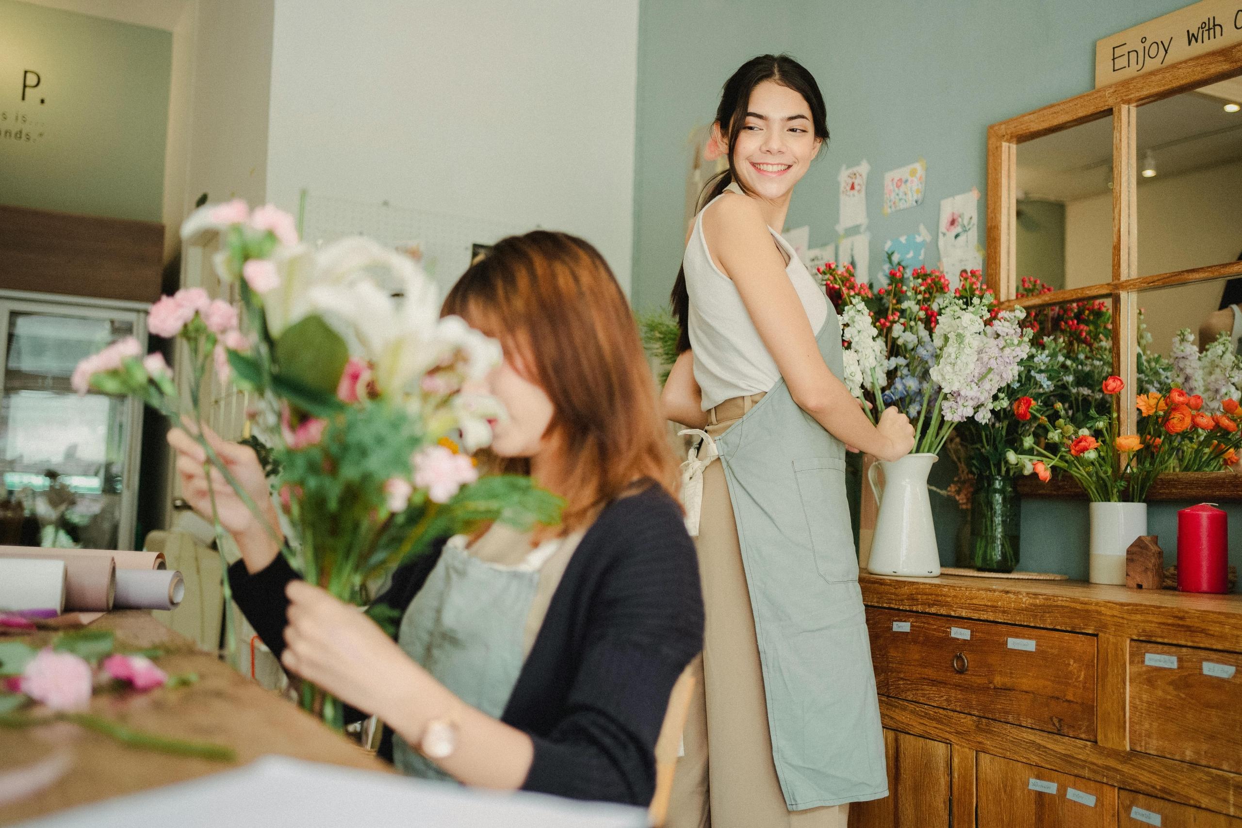 florist and her assistant arranging flowers into bouquets