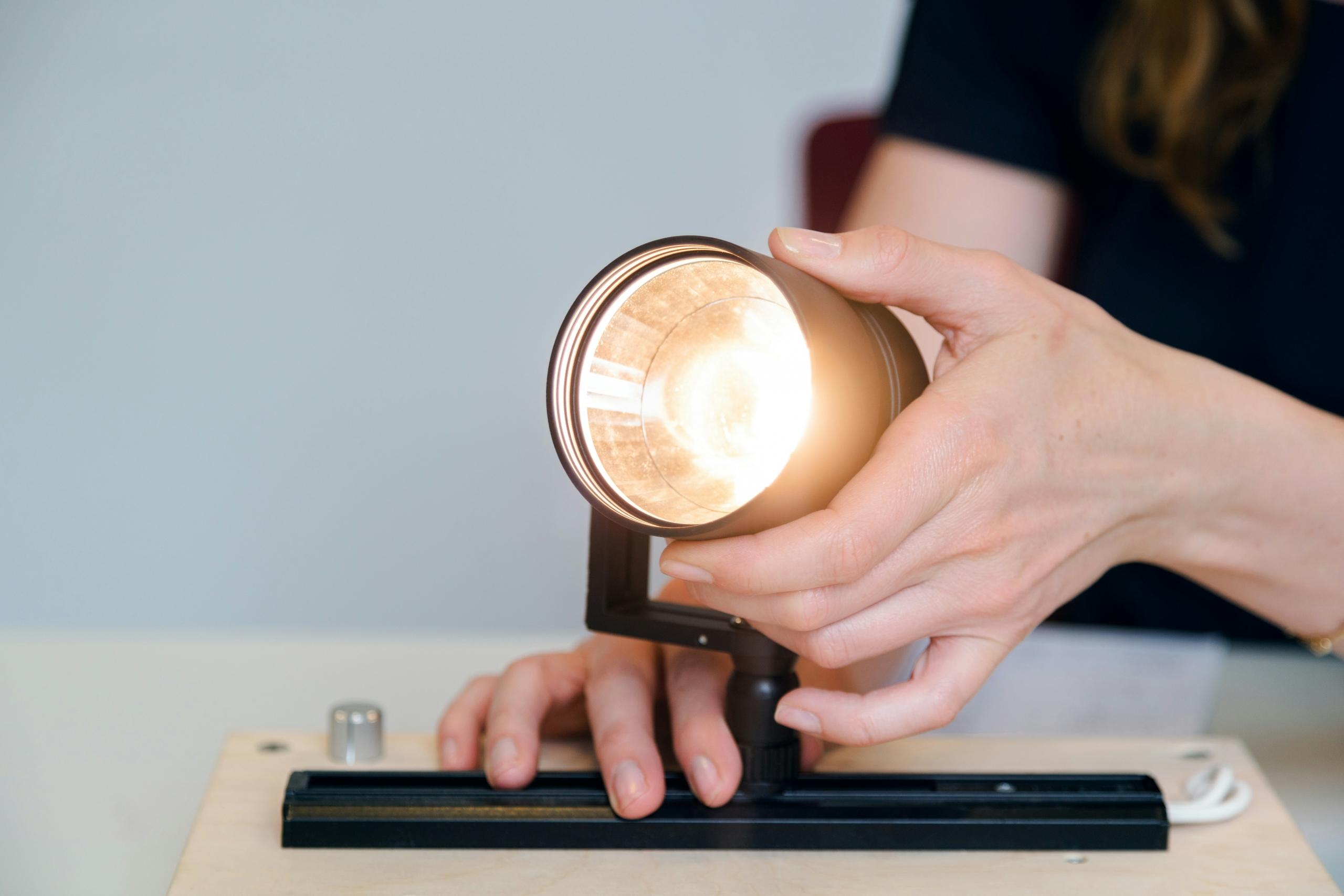 person holding black ceramic lightbulb