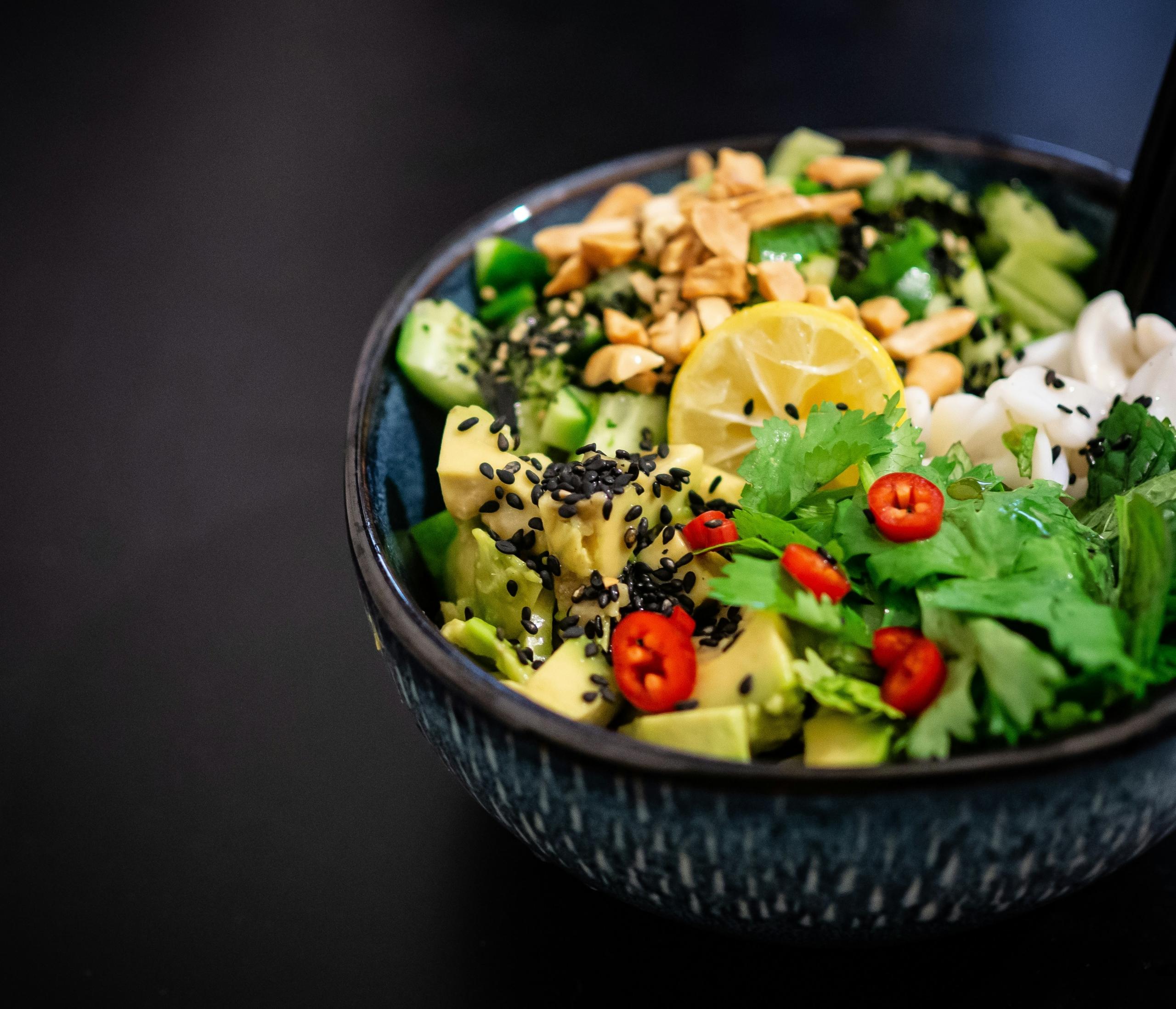 bowl filled with avocado, fresh chillies, coriander, rice, peanuts and lemon