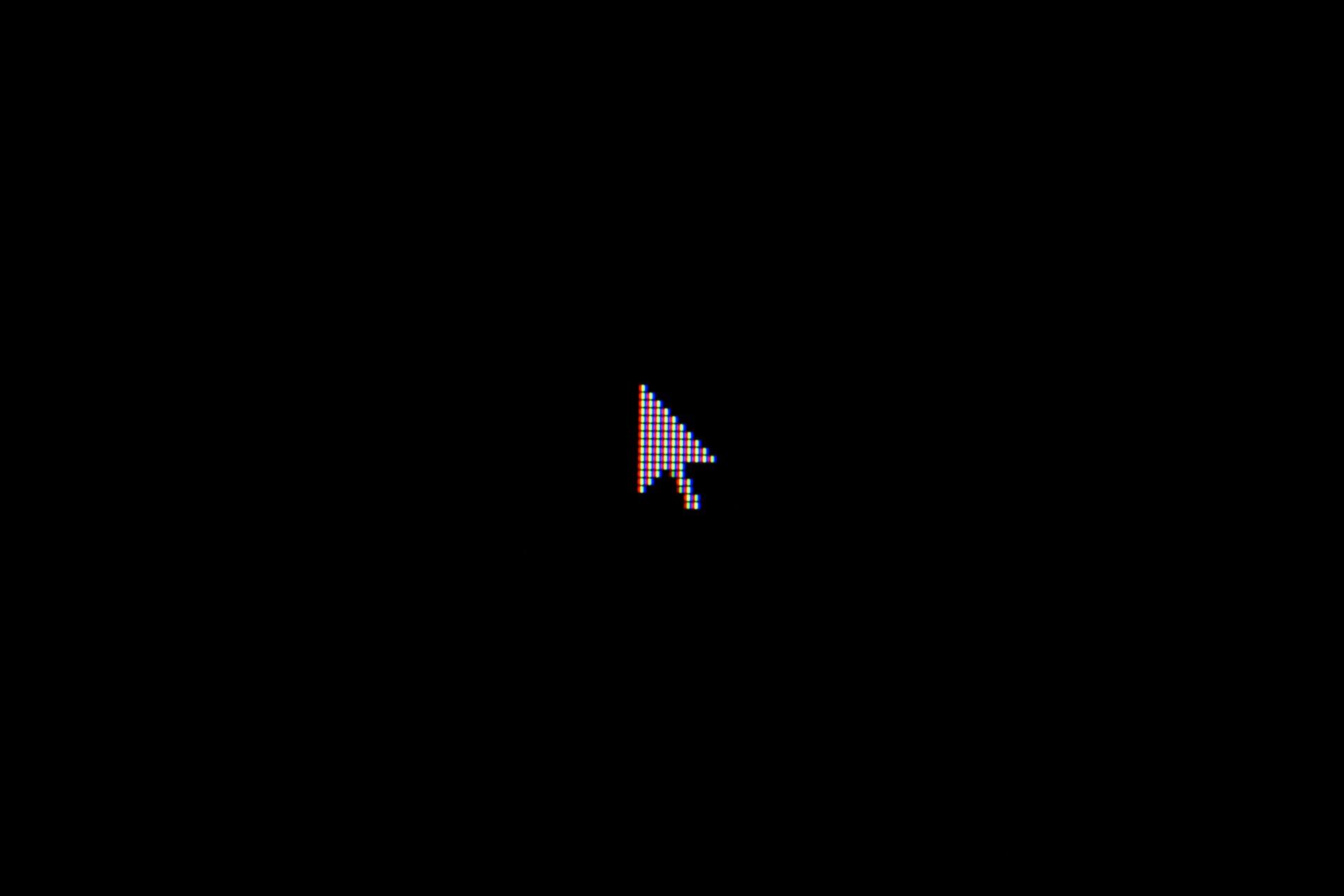 white computer mouse cursor hovering on black background