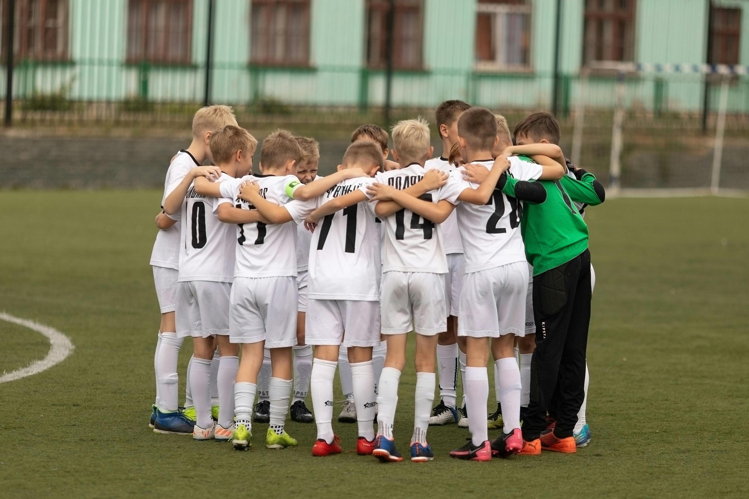 boys soccer team in a huddle on the pitch